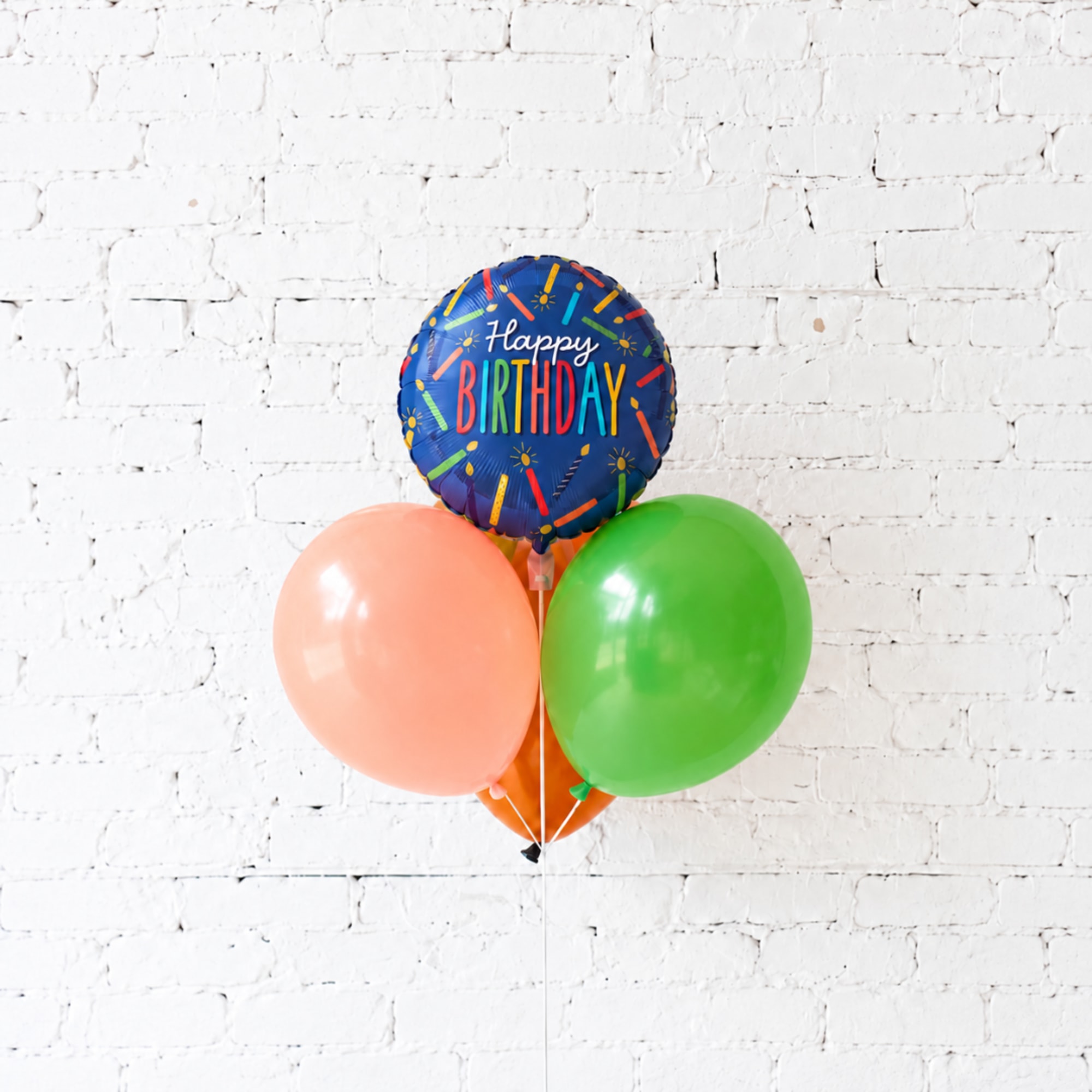 Birthday balloon bouquet with a blue "Happy Birthday" balloon and two round balloons