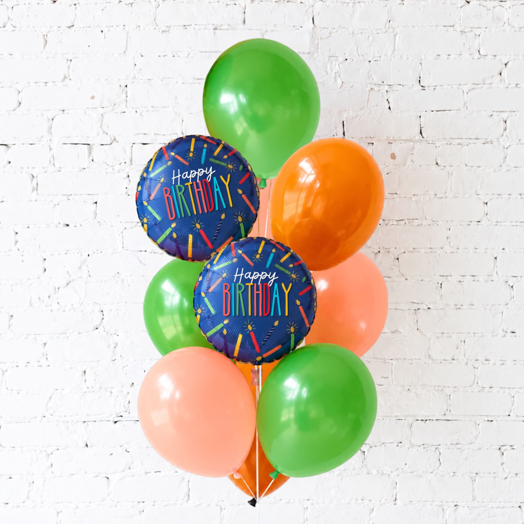 Cluster of birthday balloons in green, orange, and peach with two "Happy Birthday" balloons