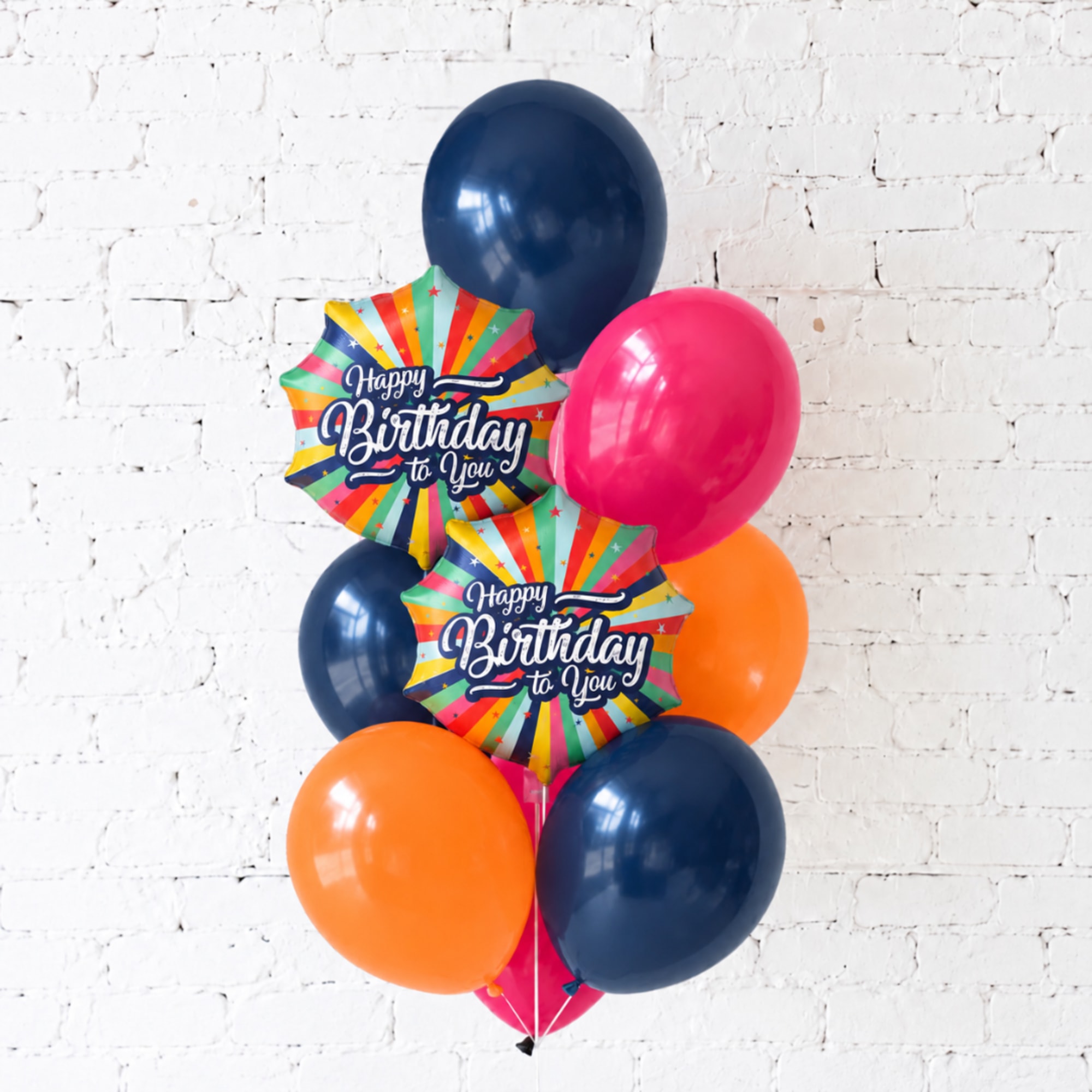 Birthday balloon bouquet with colorful balloons and two starburst birthday signs
