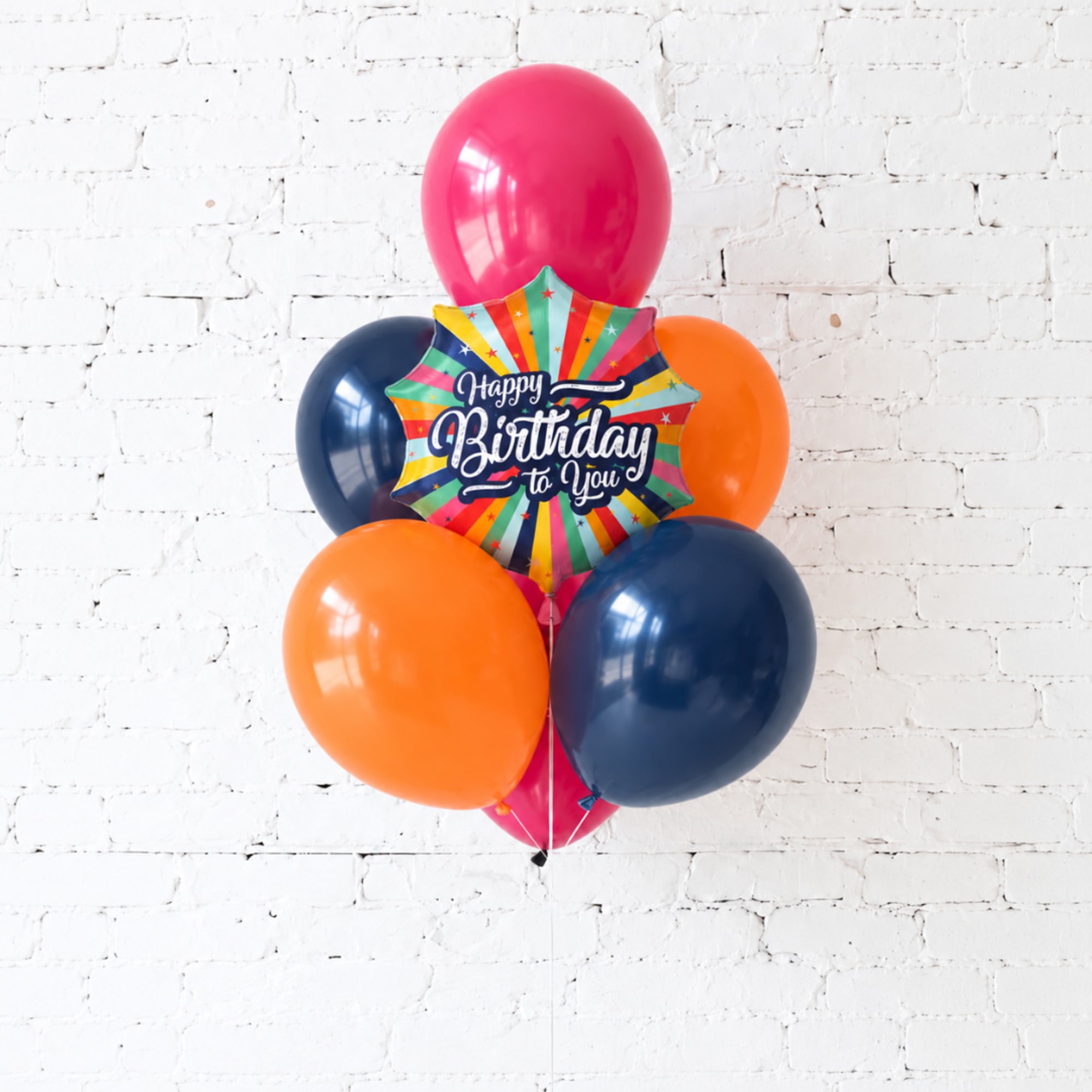 Birthday balloon bouquet with a colorful starburst foil balloon and round balloons