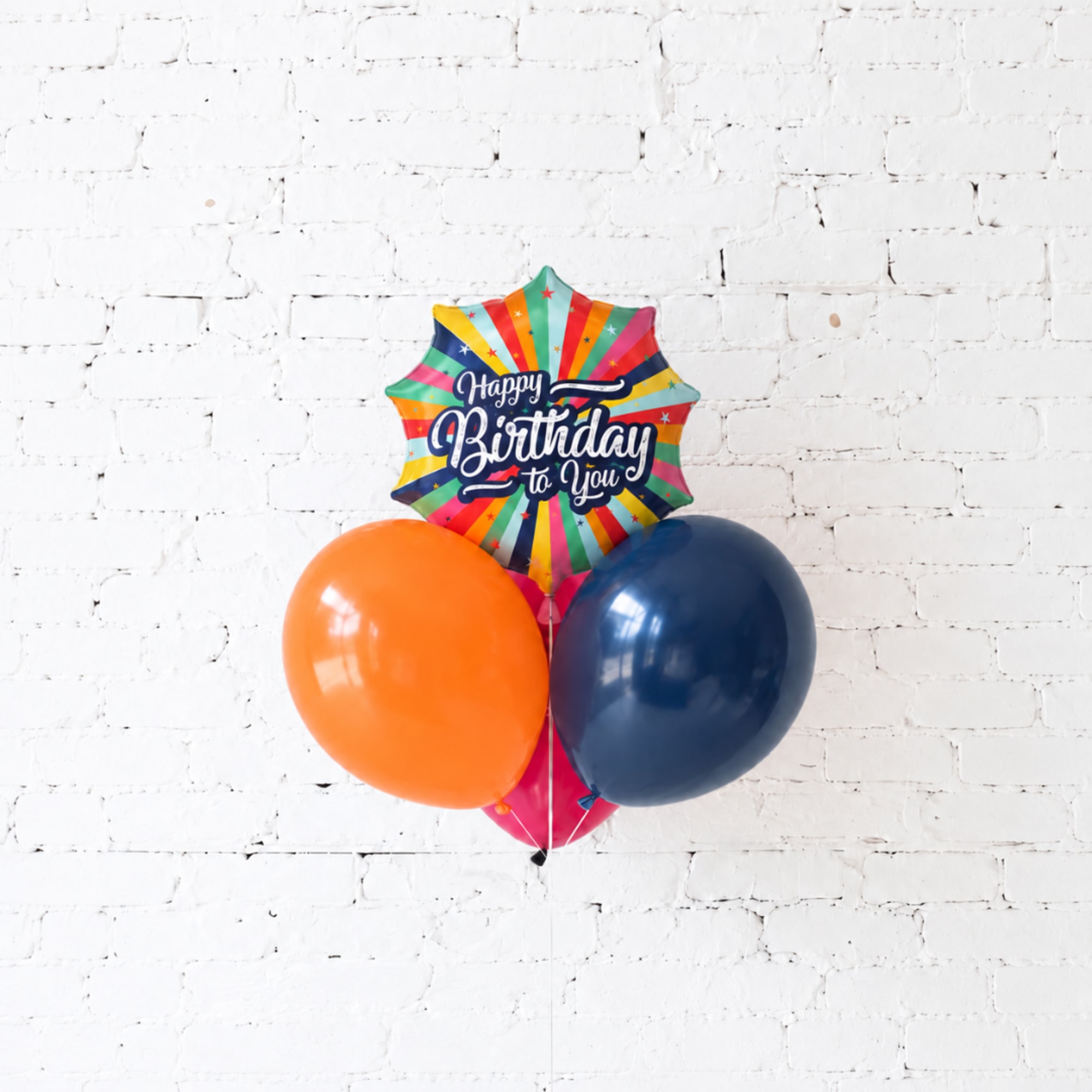 Birthday balloon cluster with a starburst foil balloon and two latex balloons