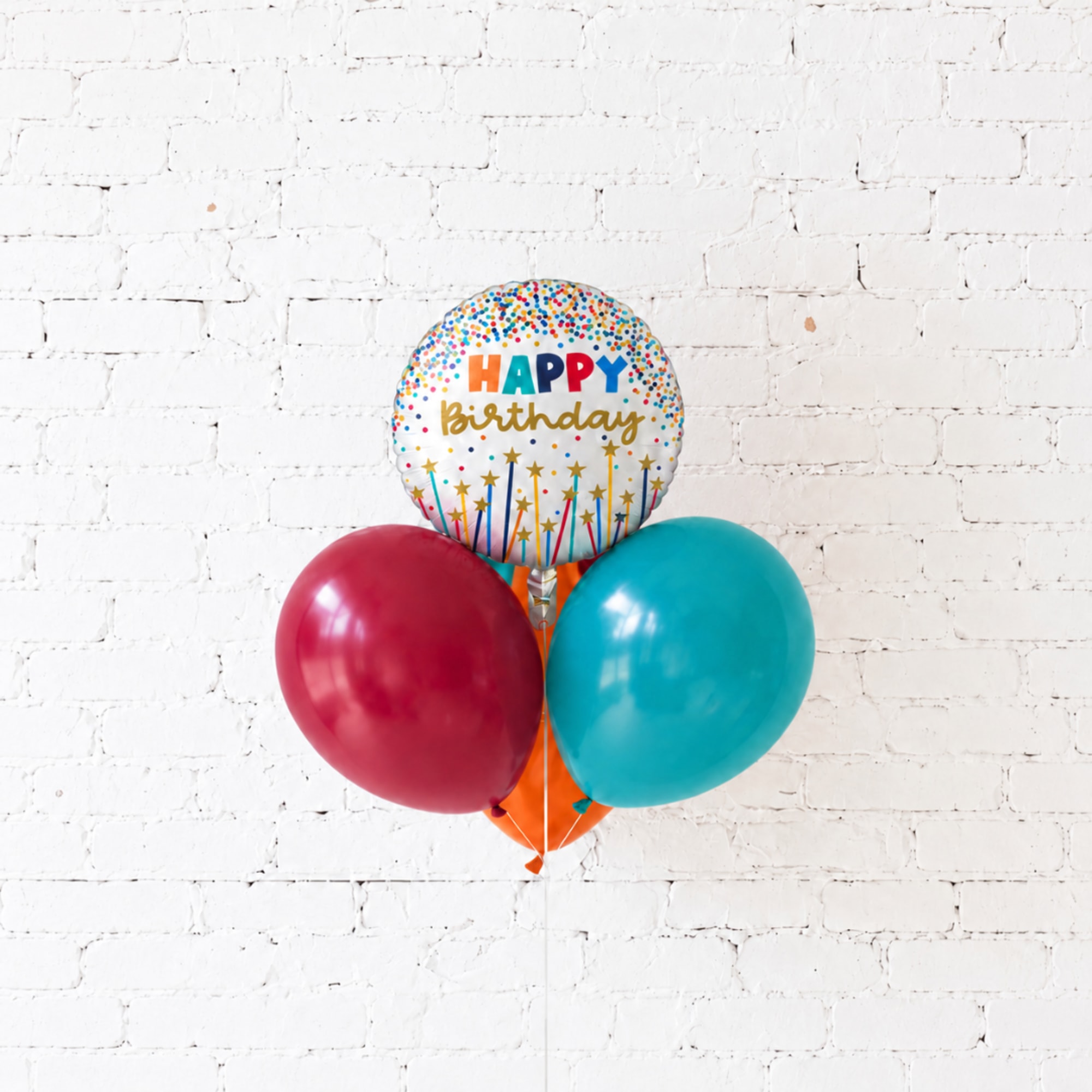 Birthday balloon cluster with a printed happy birthday balloon and two round balloons