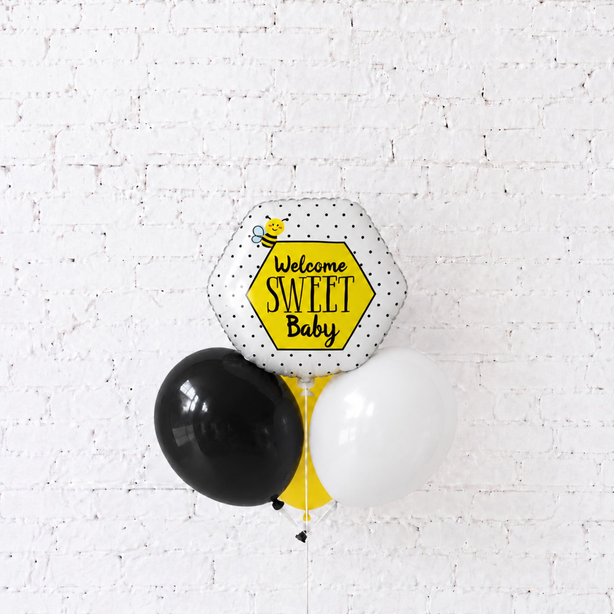 Baby shower balloon cluster with a "Welcome Sweet Baby" foil balloon