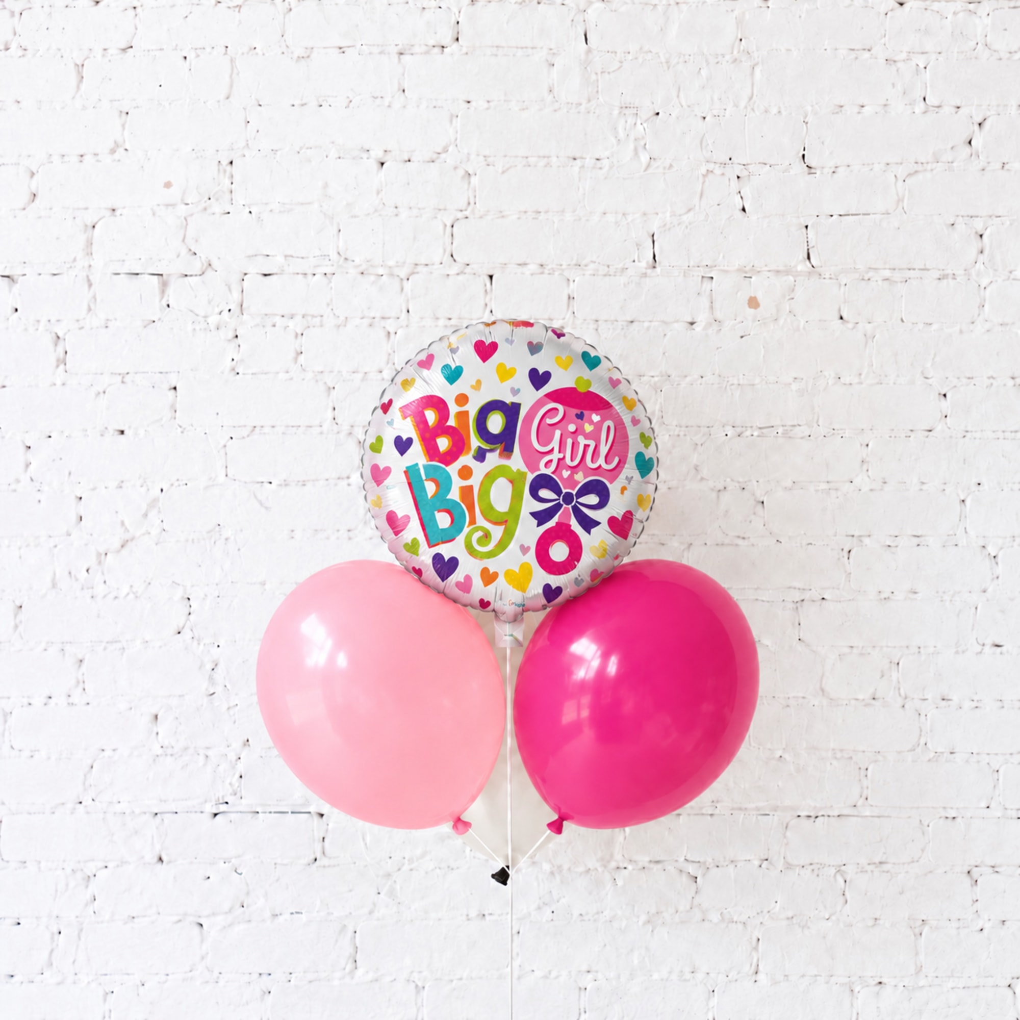 Three balloons, including a "Big Girl" foil balloon and two pink latex balloons