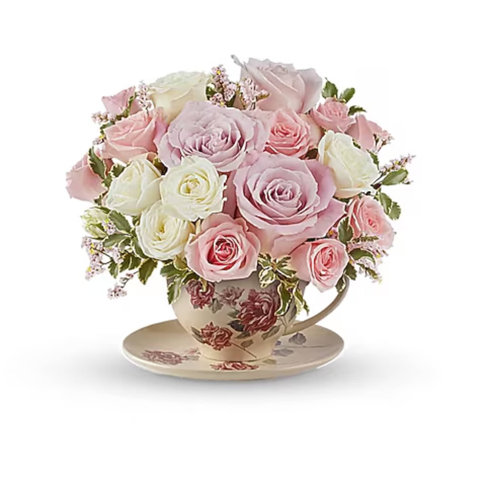 Pink and white roses arranged in a floral teacup on a saucer