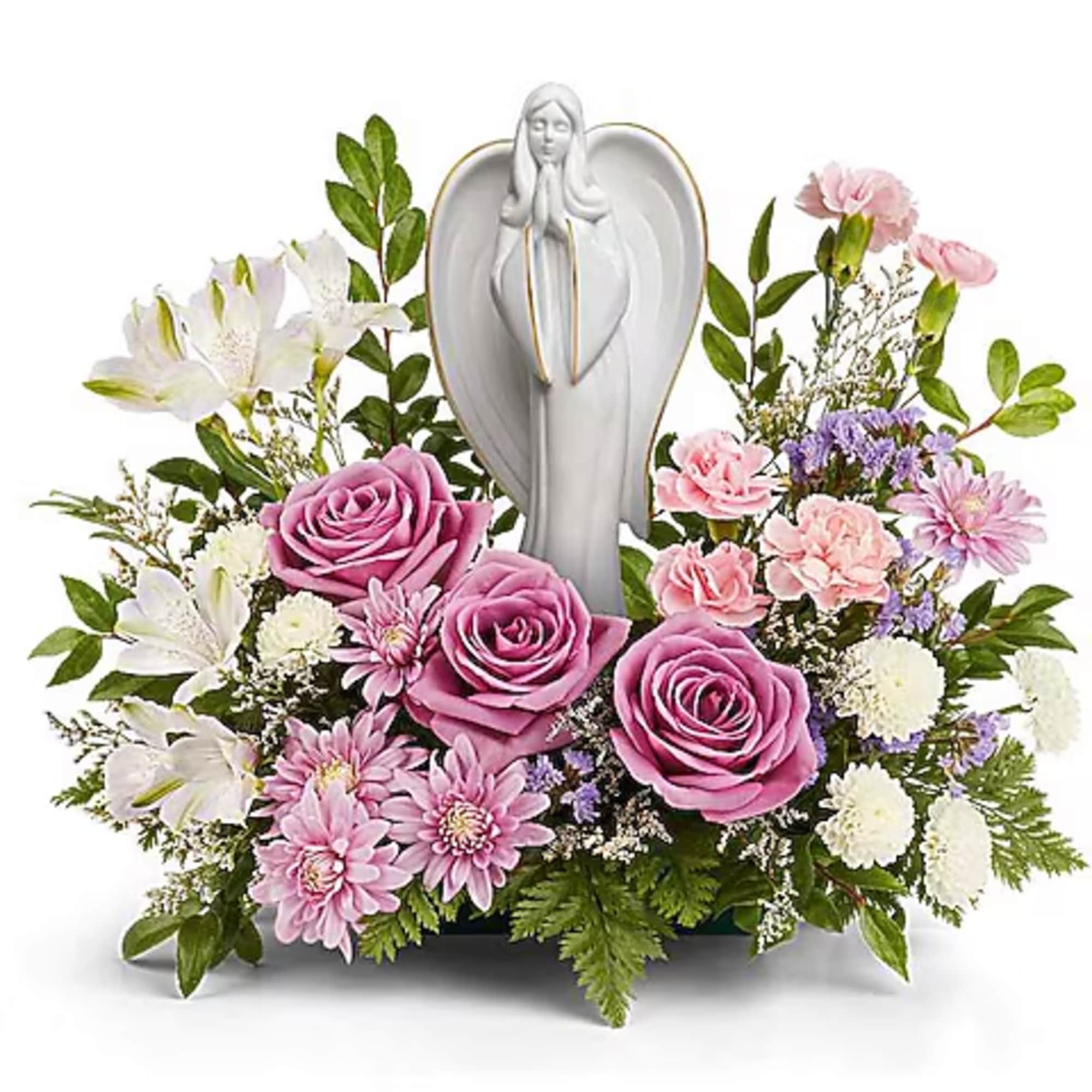 Pink roses and white lilies arranged around a white angel figurine