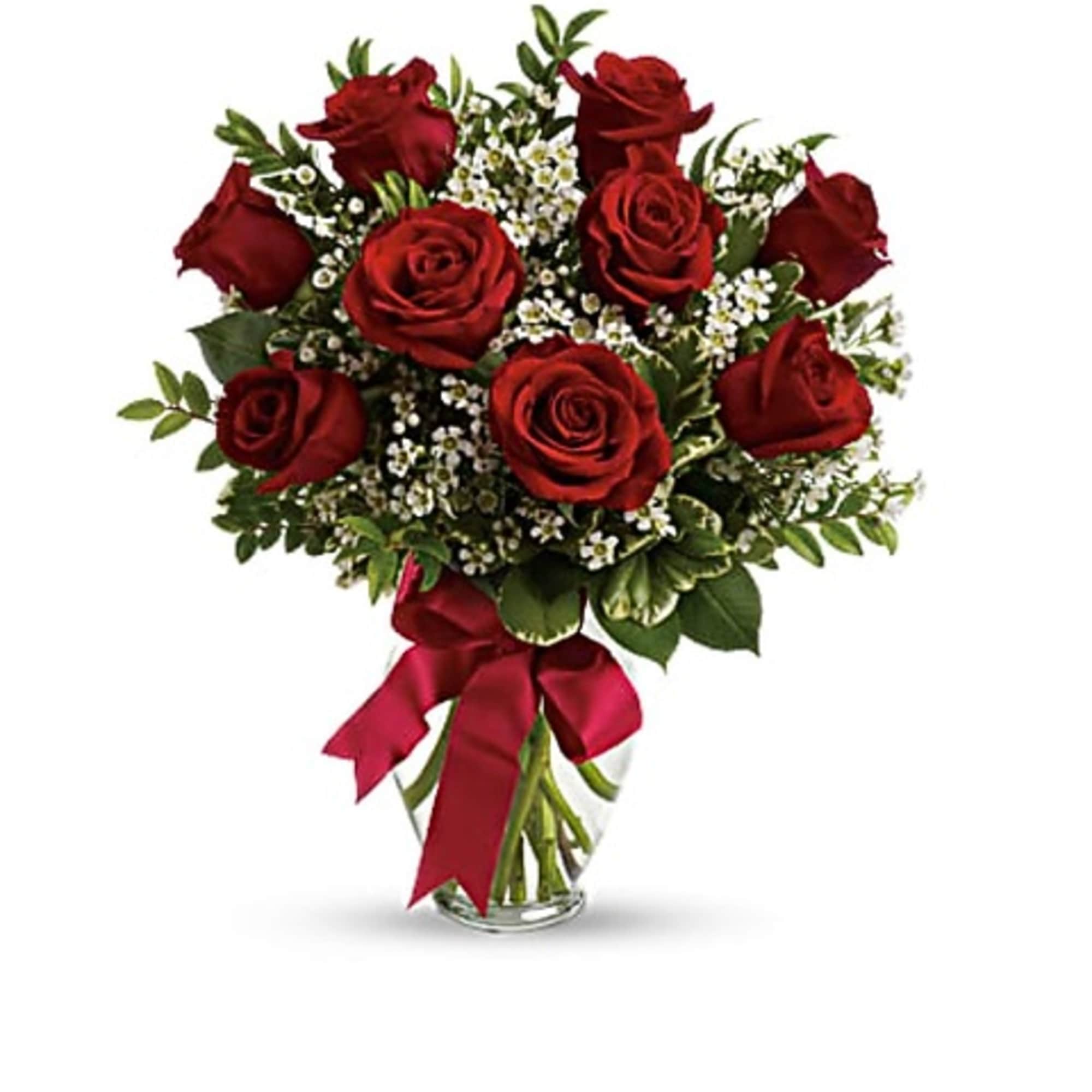 Bouquet of red roses with small white filler flowers in a glass vase