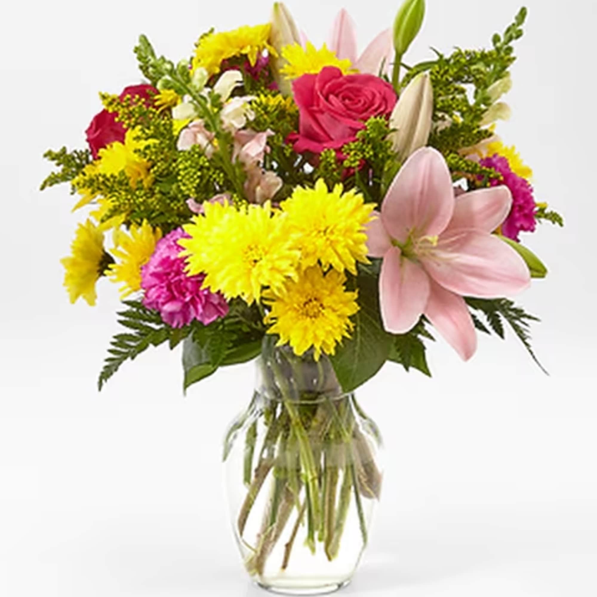 Mixed bouquet of pink lilies, roses, and yellow chrysanthemums in a glass vase