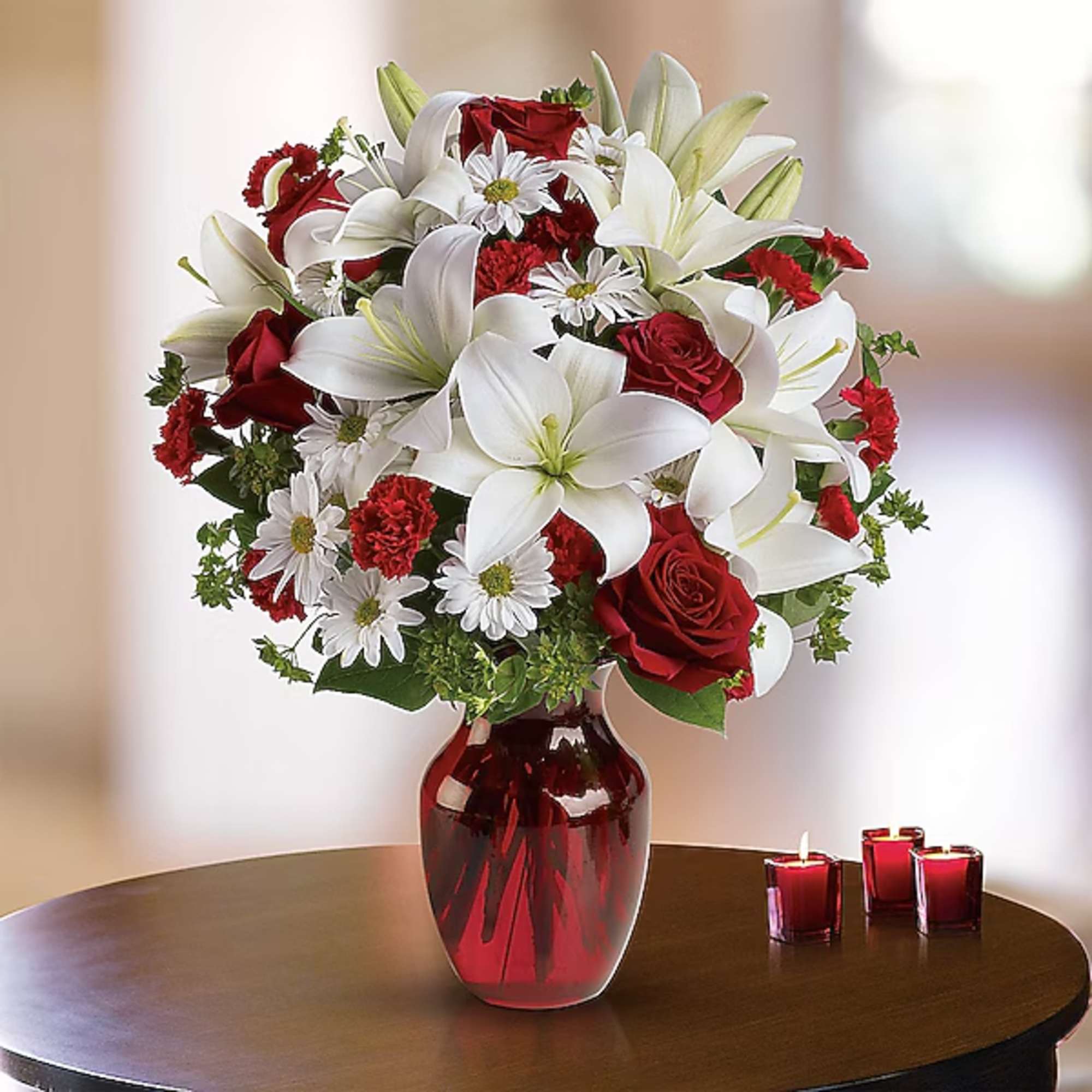 Red roses and white lilies in a red glass vase
