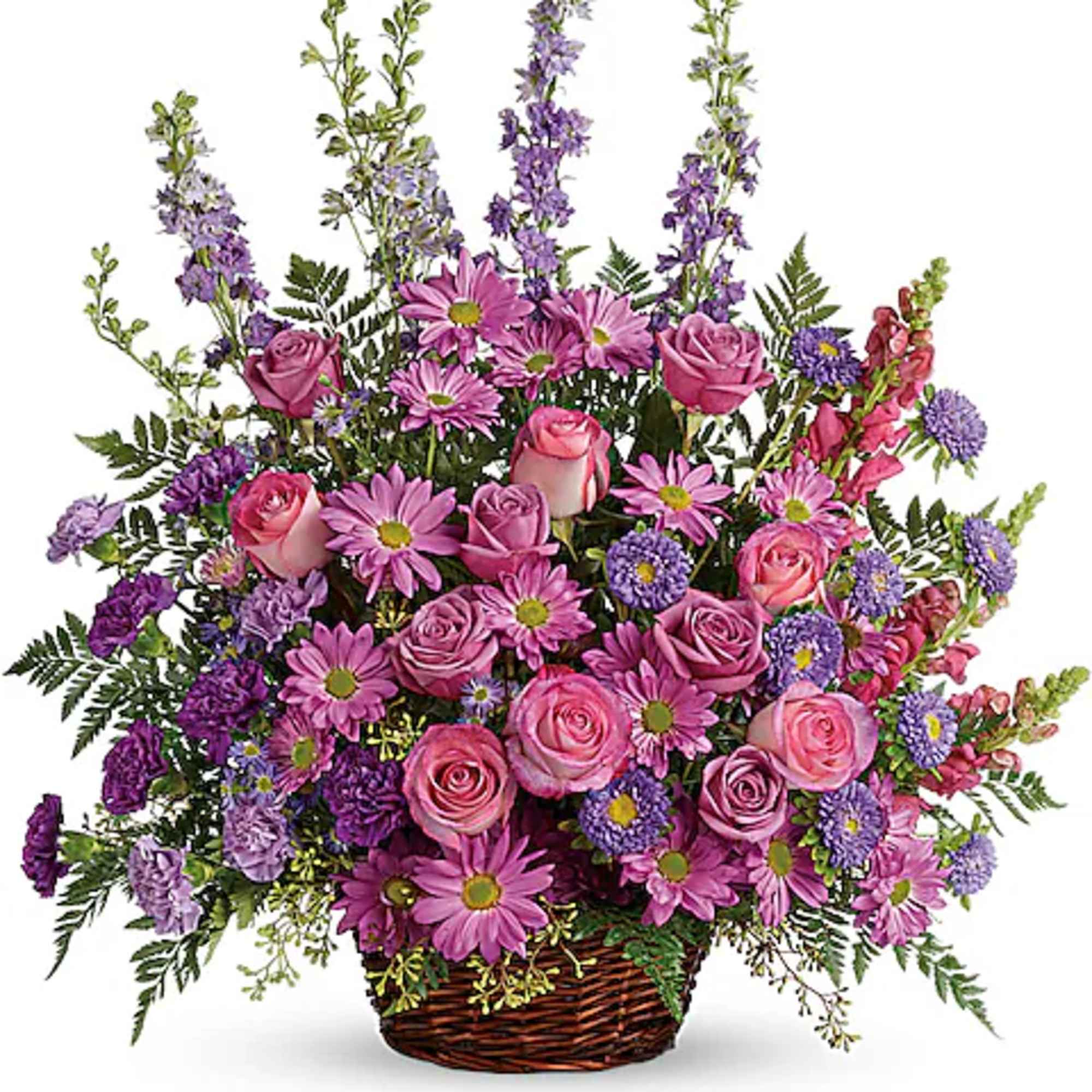 Pink and purple mixed flower arrangement in a wicker basket