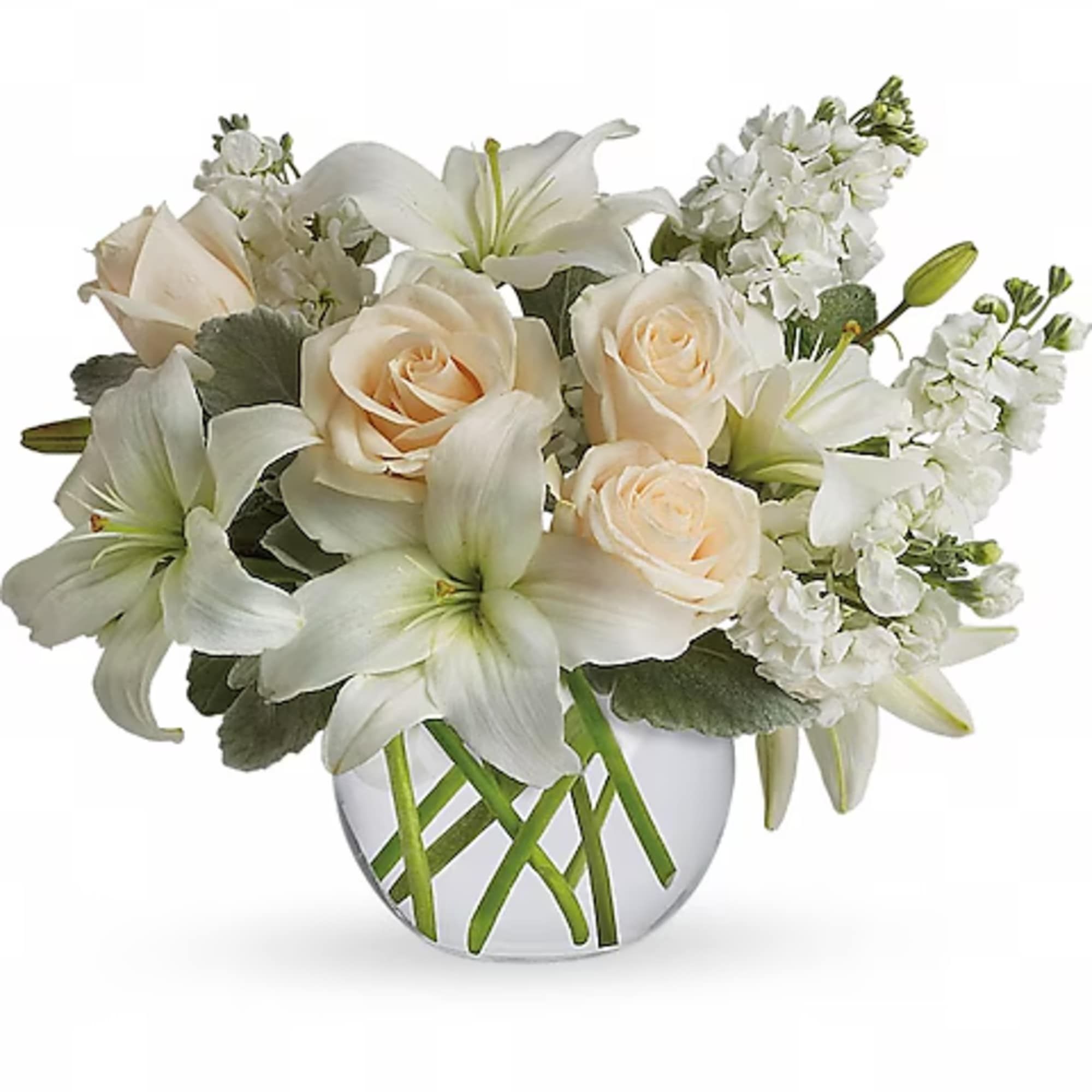 White lilies and cream roses arranged in a clear glass vase