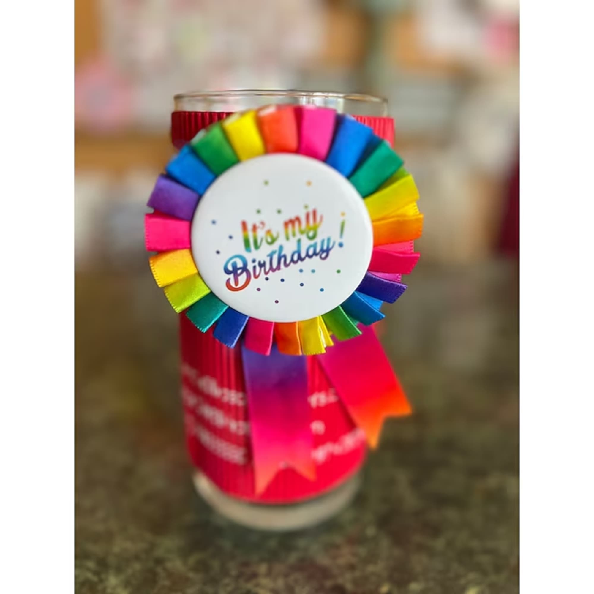 Birthday ribbon rosette attached to a glass candle holder
