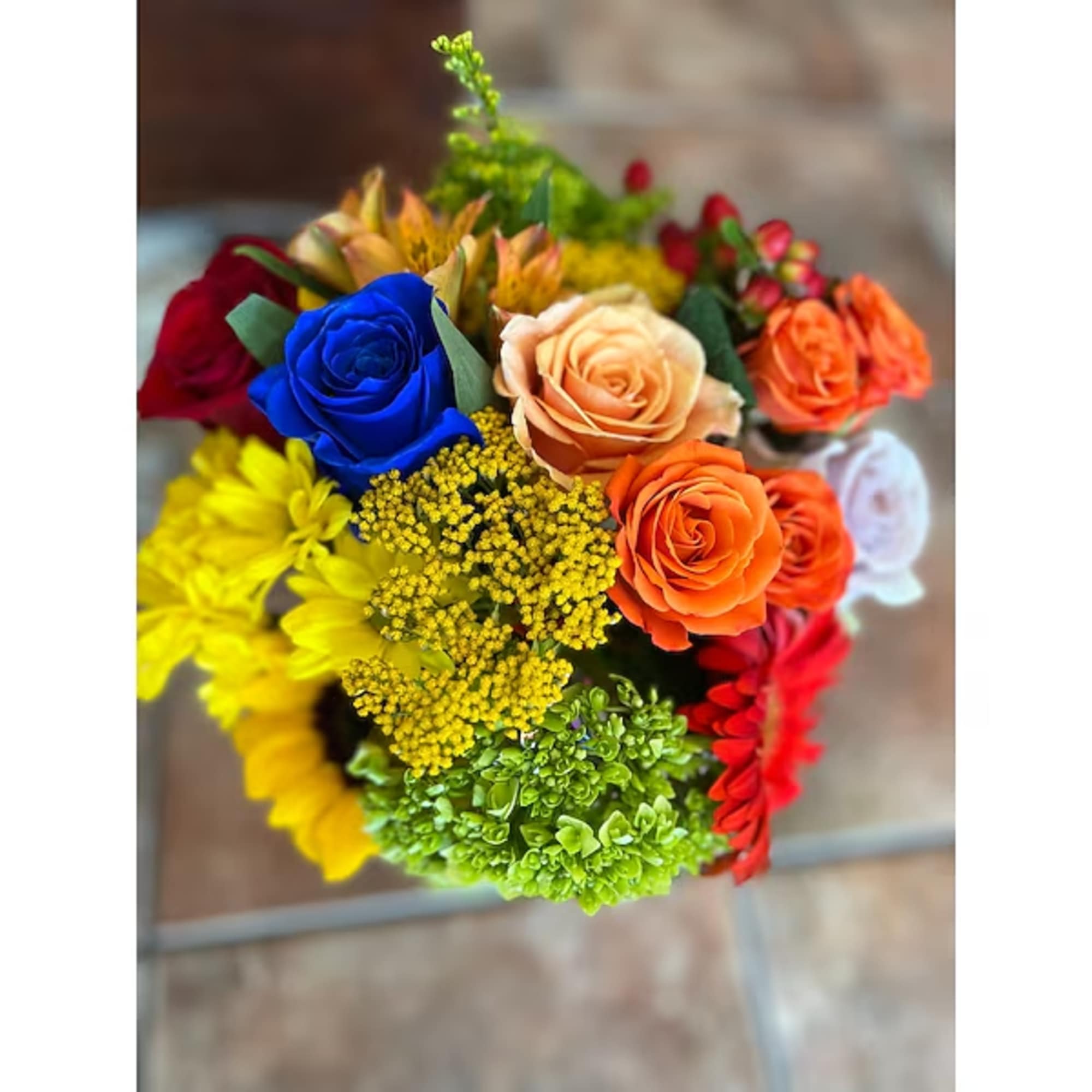 Colorful bouquet of roses and daisies with yellow filler flowers