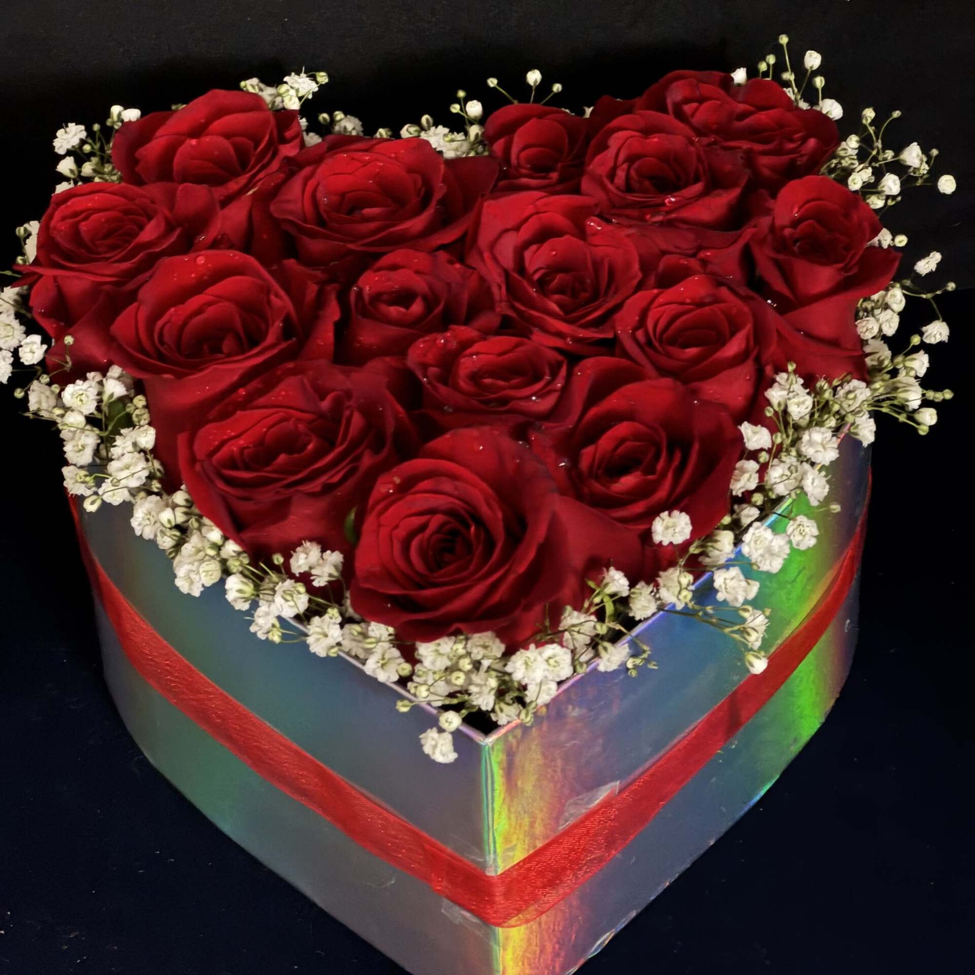 Heart-shaped box filled with red roses and white baby's breath