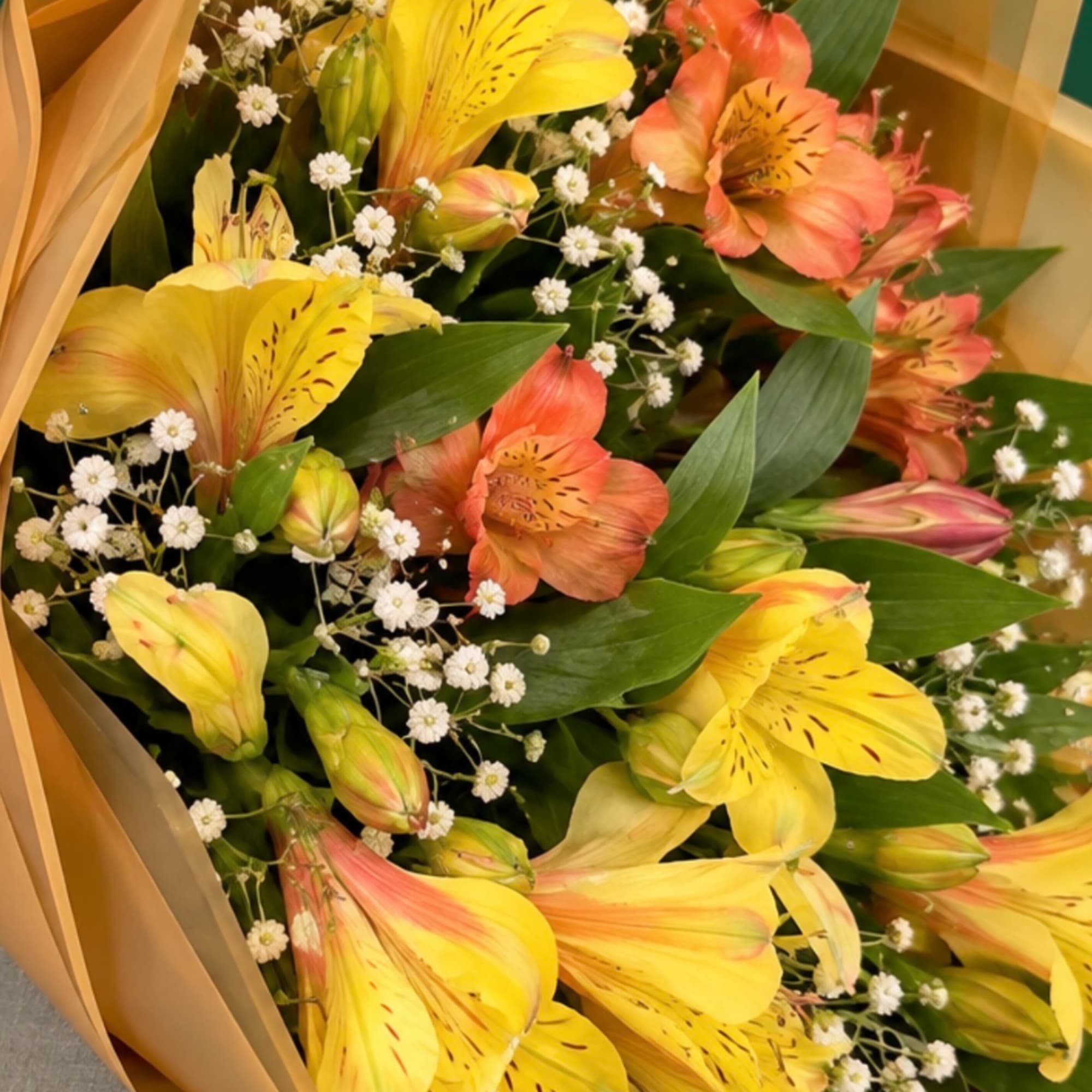 Bouquet of yellow and peach alstroemeria with small white filler flowers