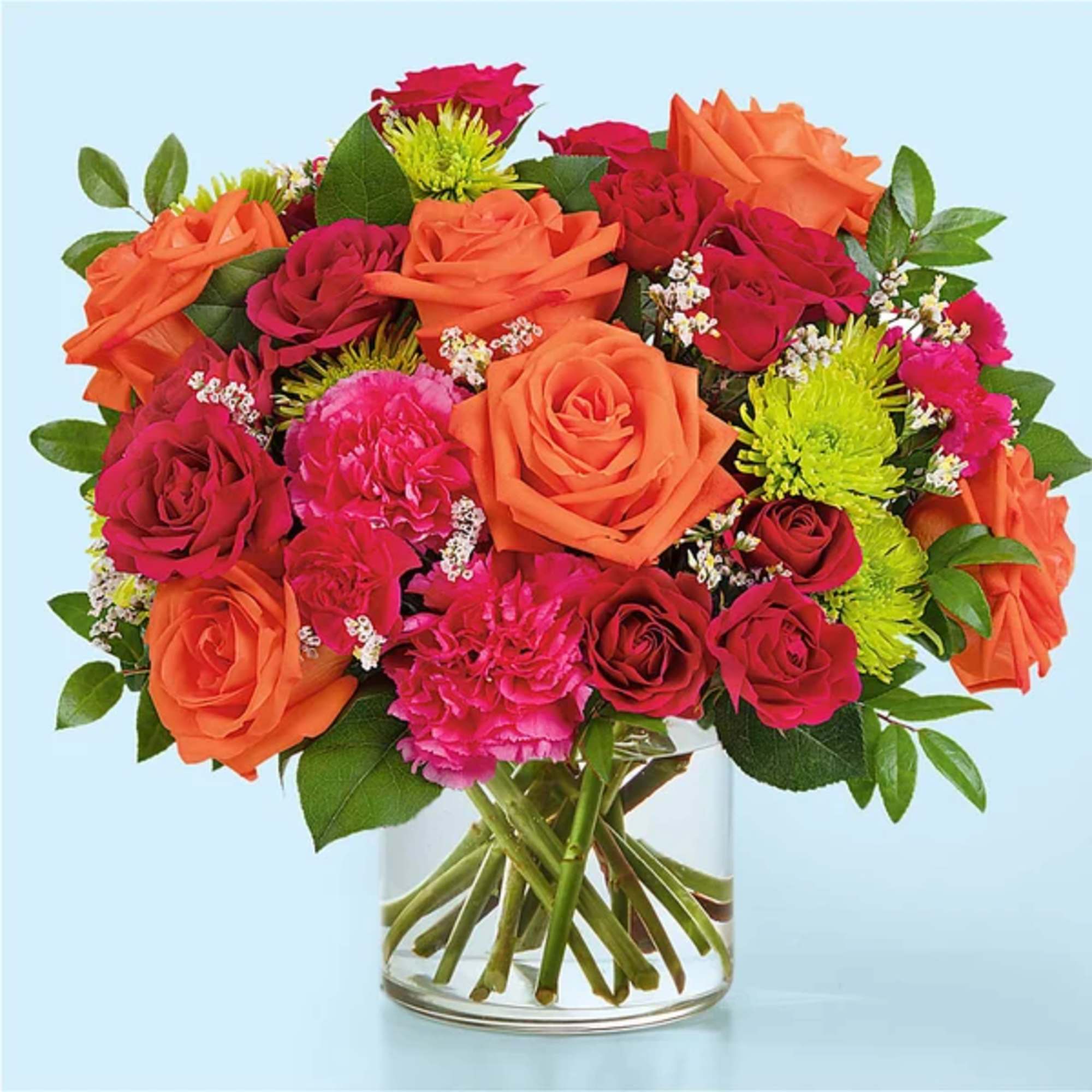 Bouquet of orange and pink roses in a clear glass vase
