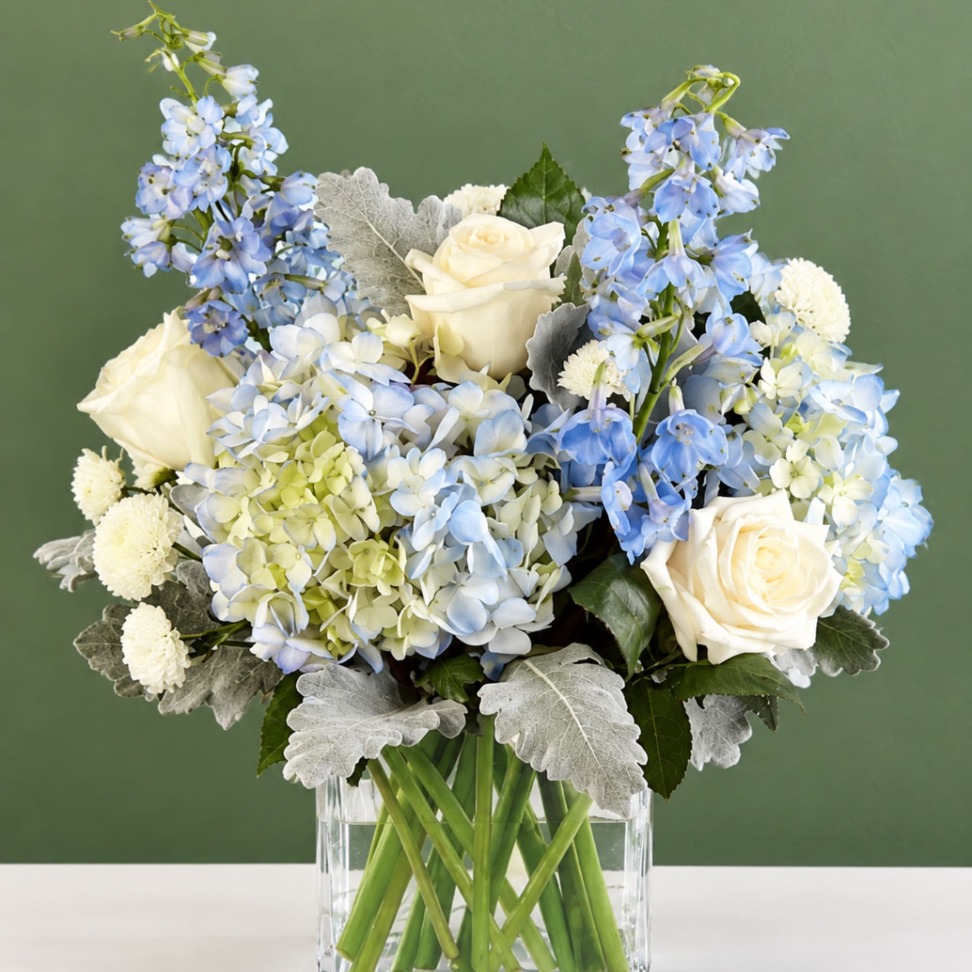Blue and white flower arrangement in a clear glass vase