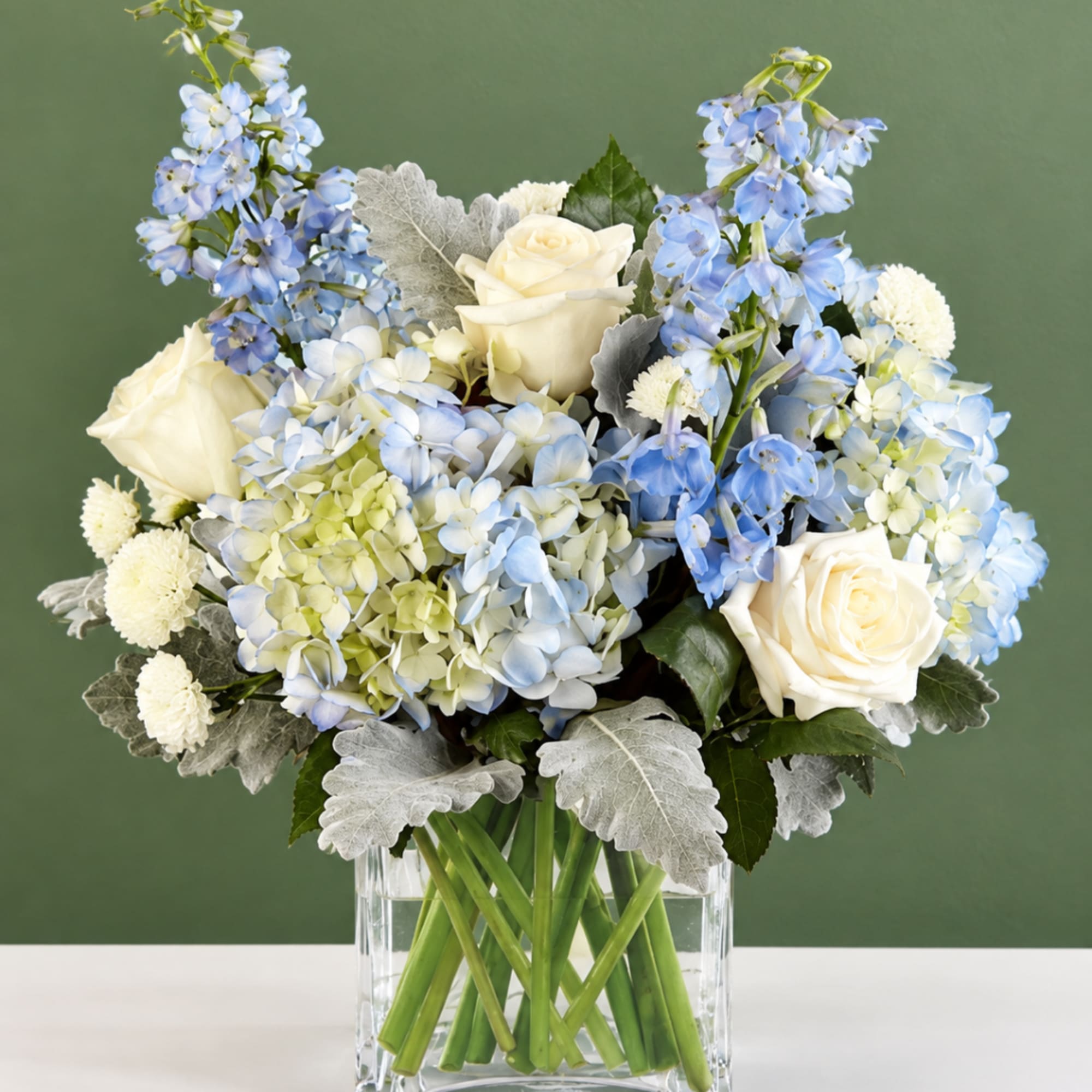 Blue and white floral arrangement in a clear glass vase