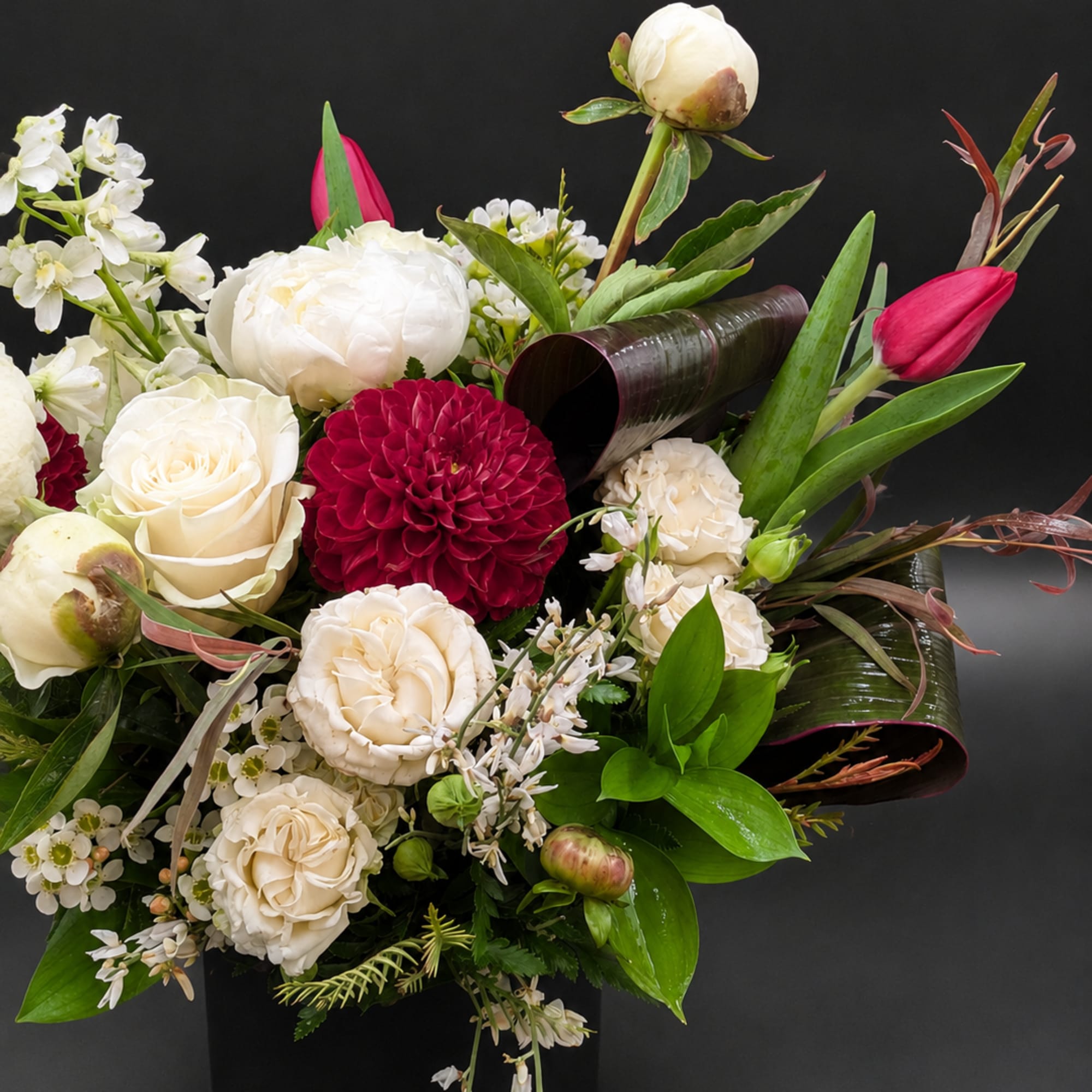 Mixed white and deep pink flowers arranged in a black vase