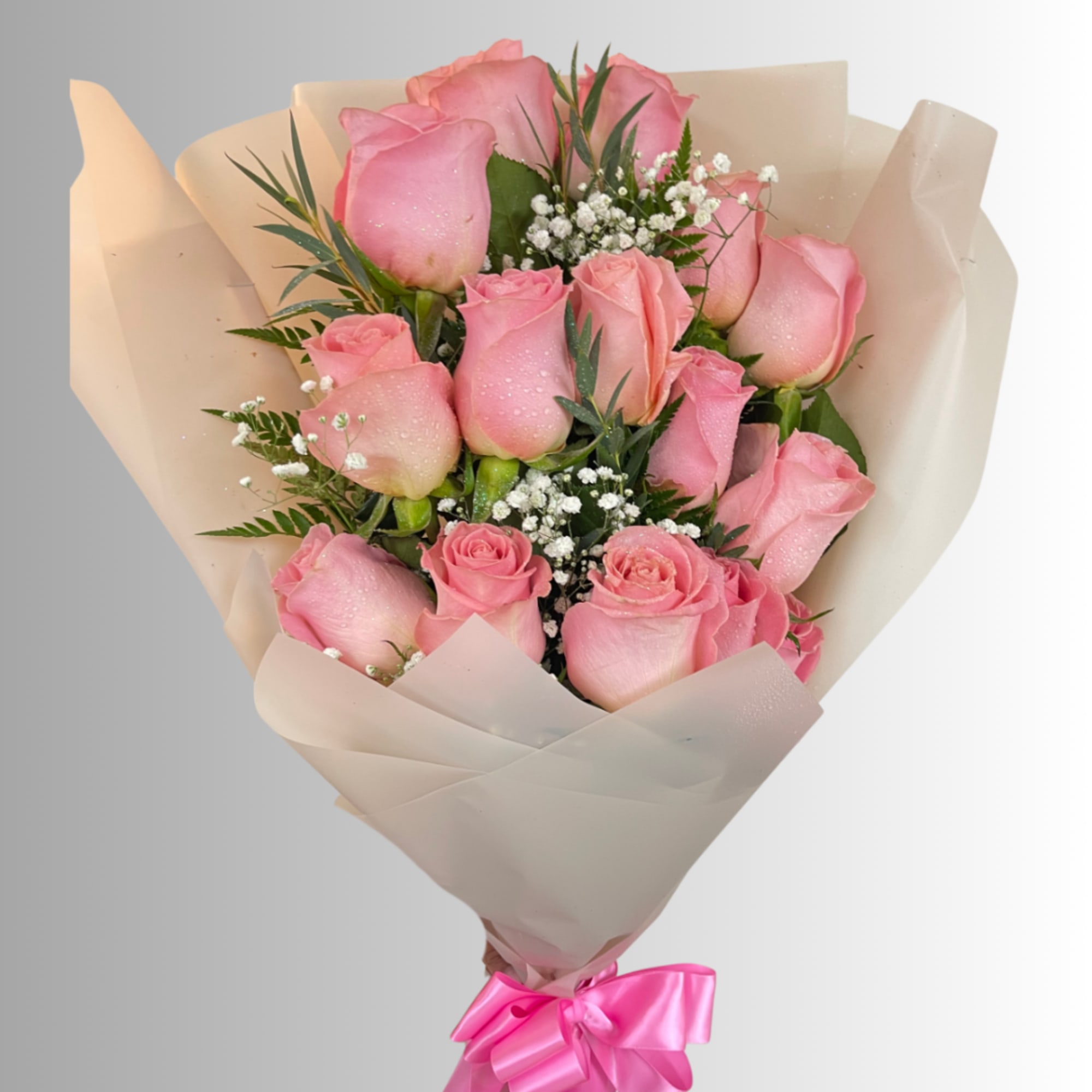 Bouquet of pink roses wrapped in beige paper with a pink ribbon