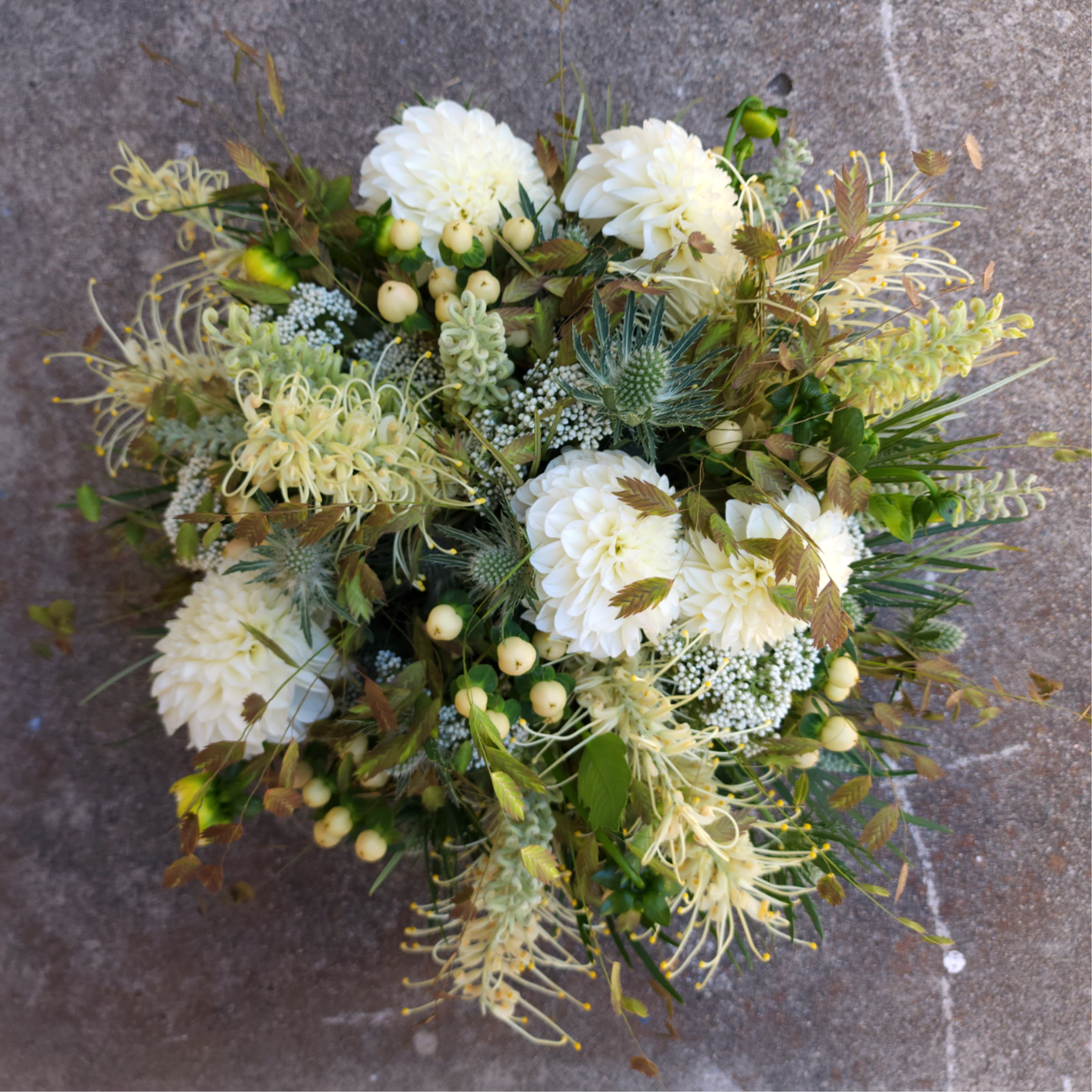 White dahlia bouquet with pale yellow accents and mixed greenery