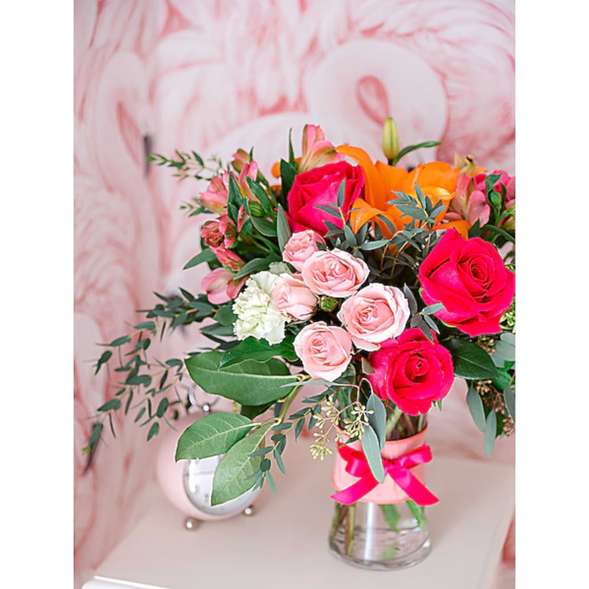 Bouquet of pink and orange roses in a clear glass vase