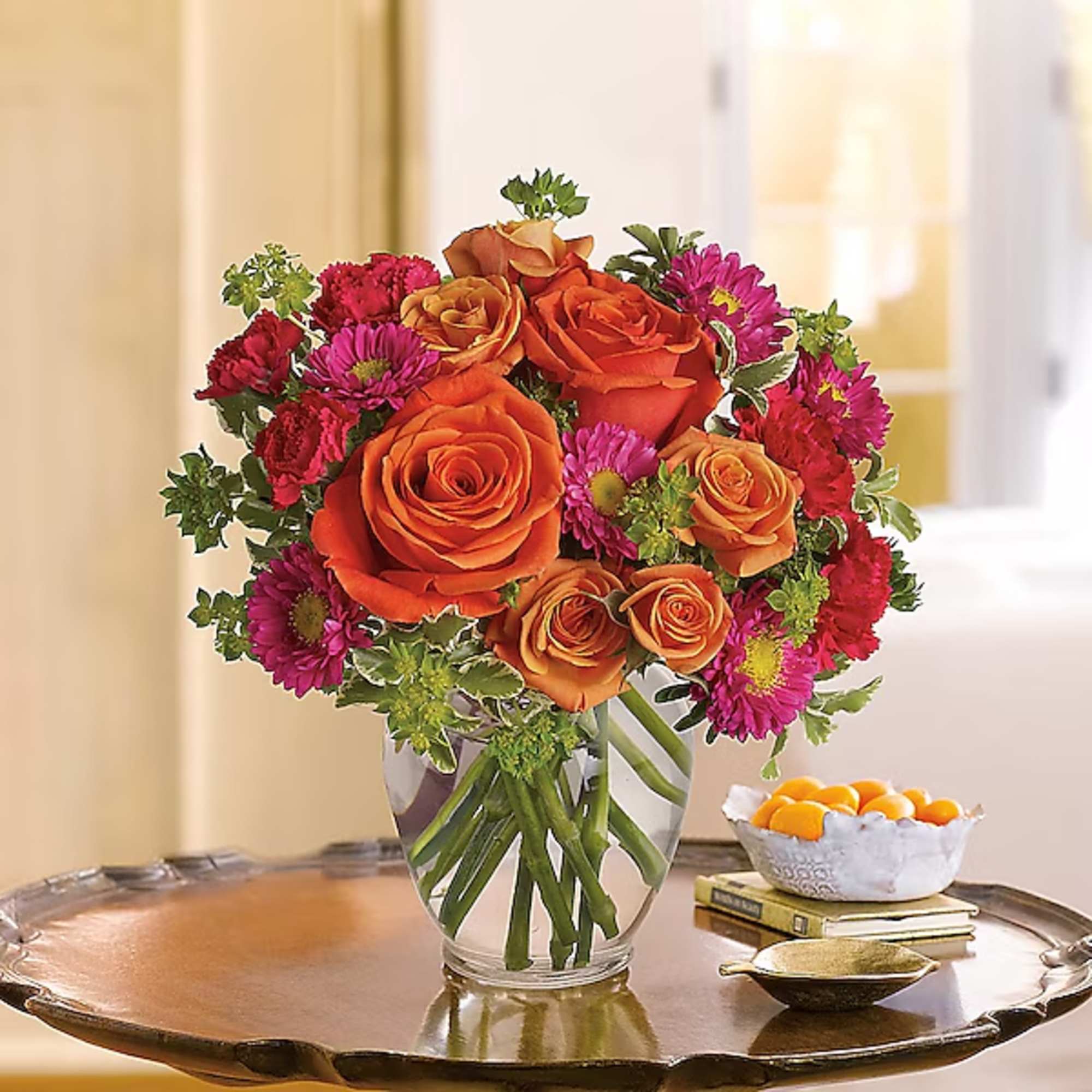 Orange roses and magenta daisies in a clear glass vase, photo 2 of 2