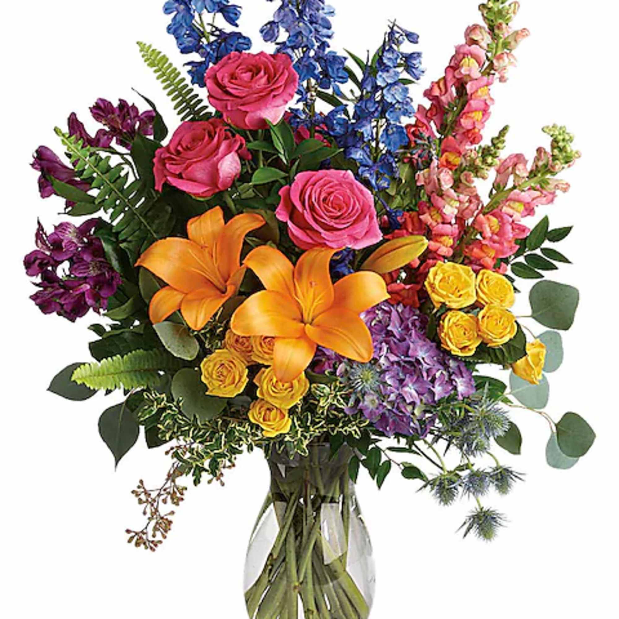 Colorful bouquet of roses, lilies, and delphinium in a clear glass vase