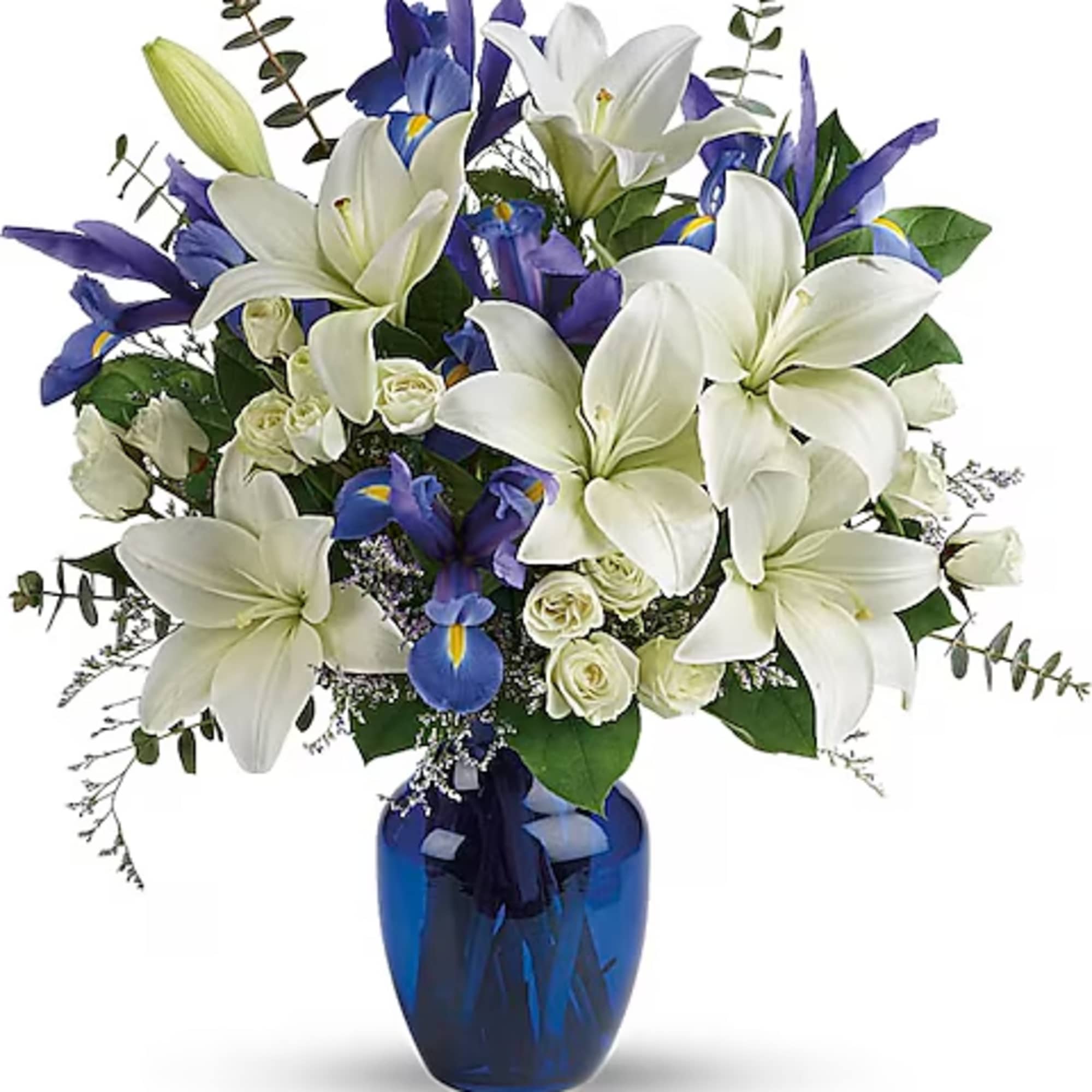 White lilies and blue irises arranged in a blue glass vase