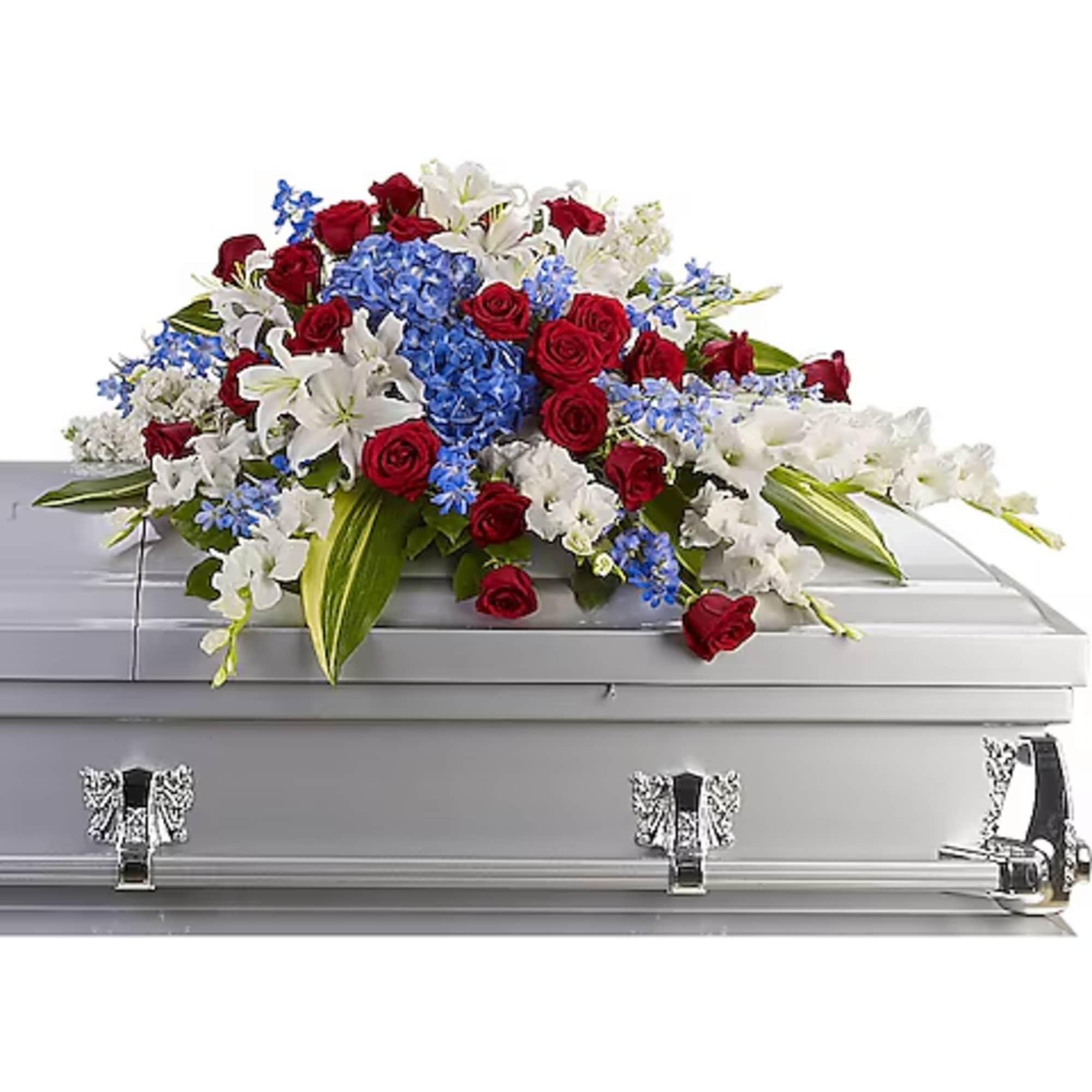 Red, white, and blue floral arrangement on a silver casket