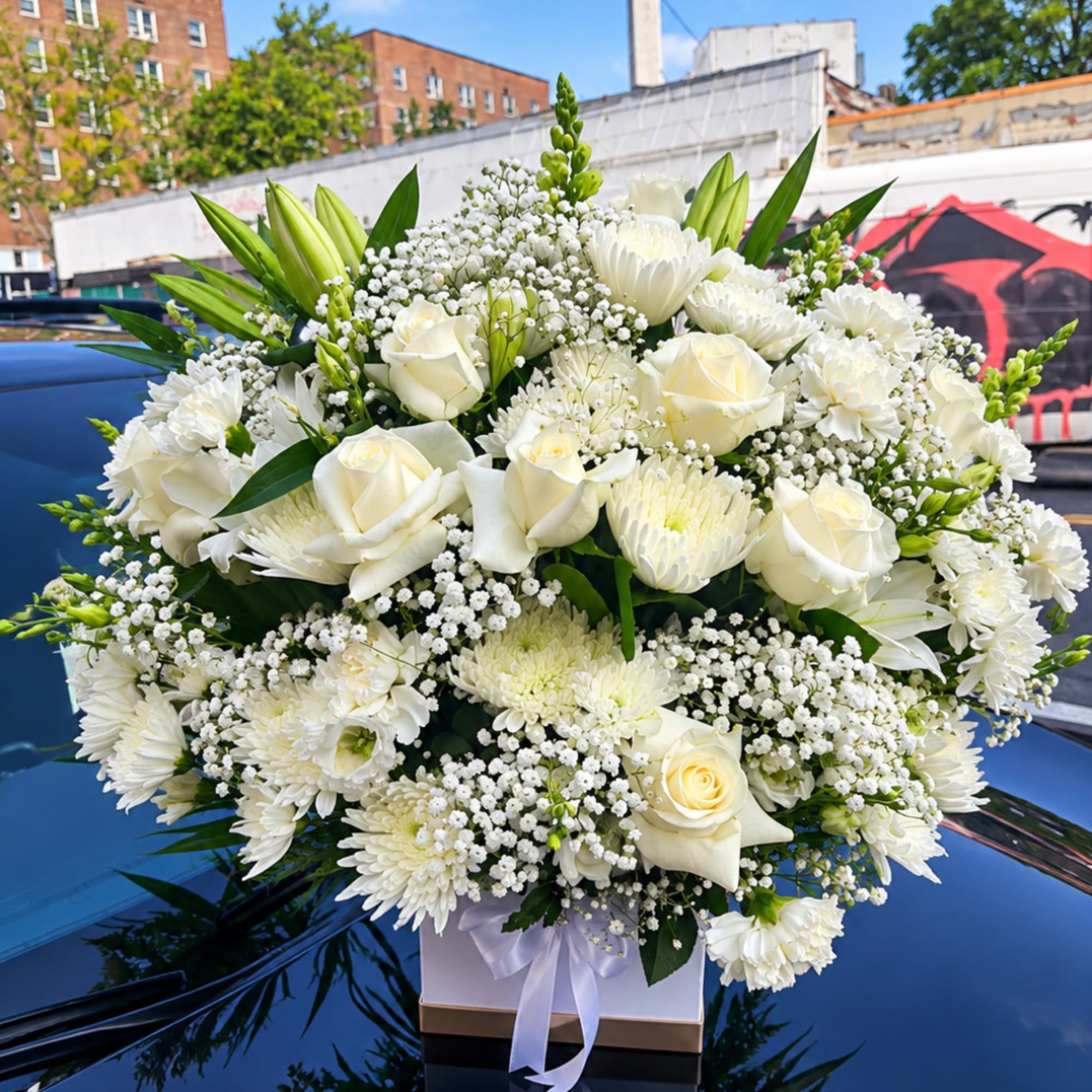 White roses and chrysanthemums in a white box with a ribbon