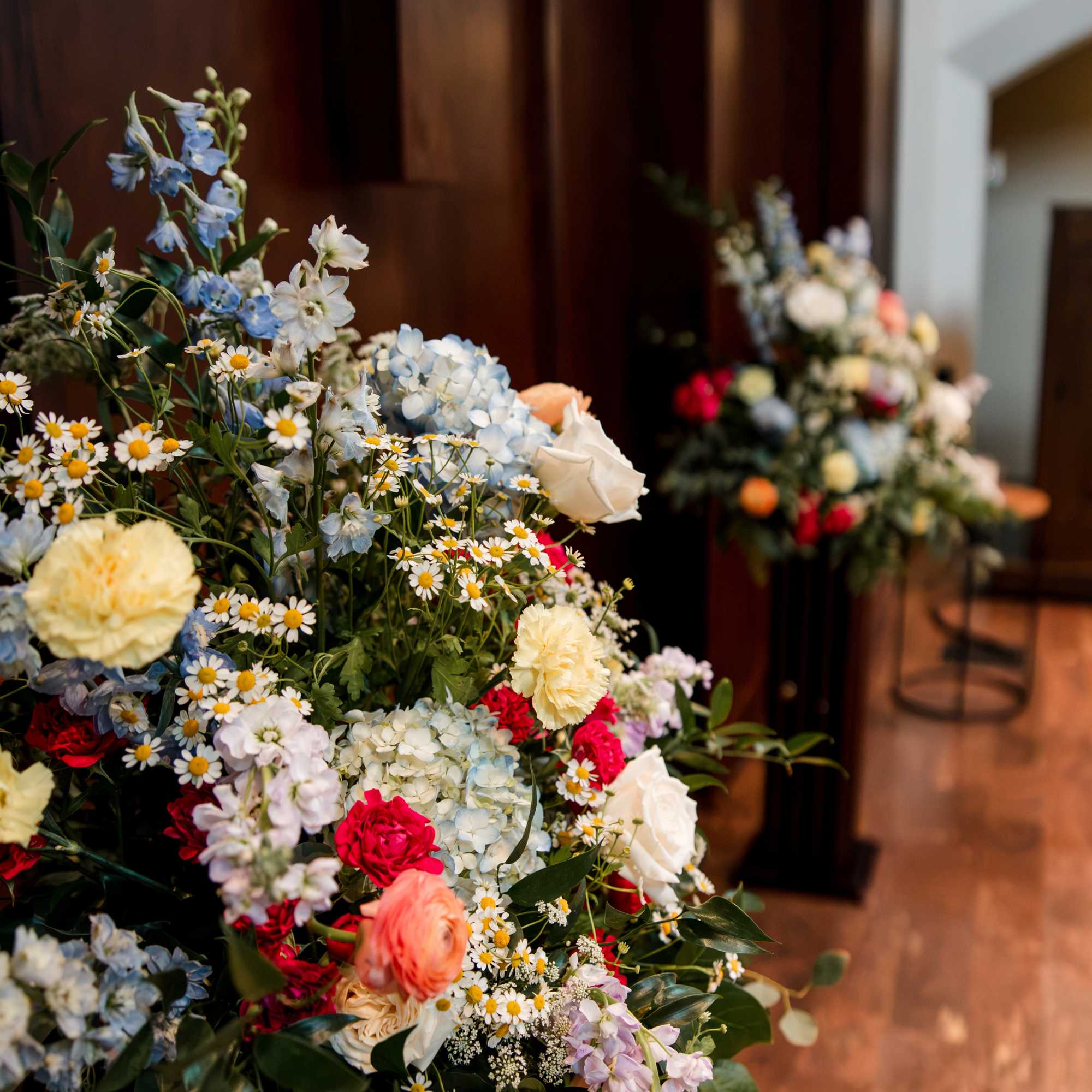 Large mixed floral arrangement with blue, white, pink, and yellow blooms