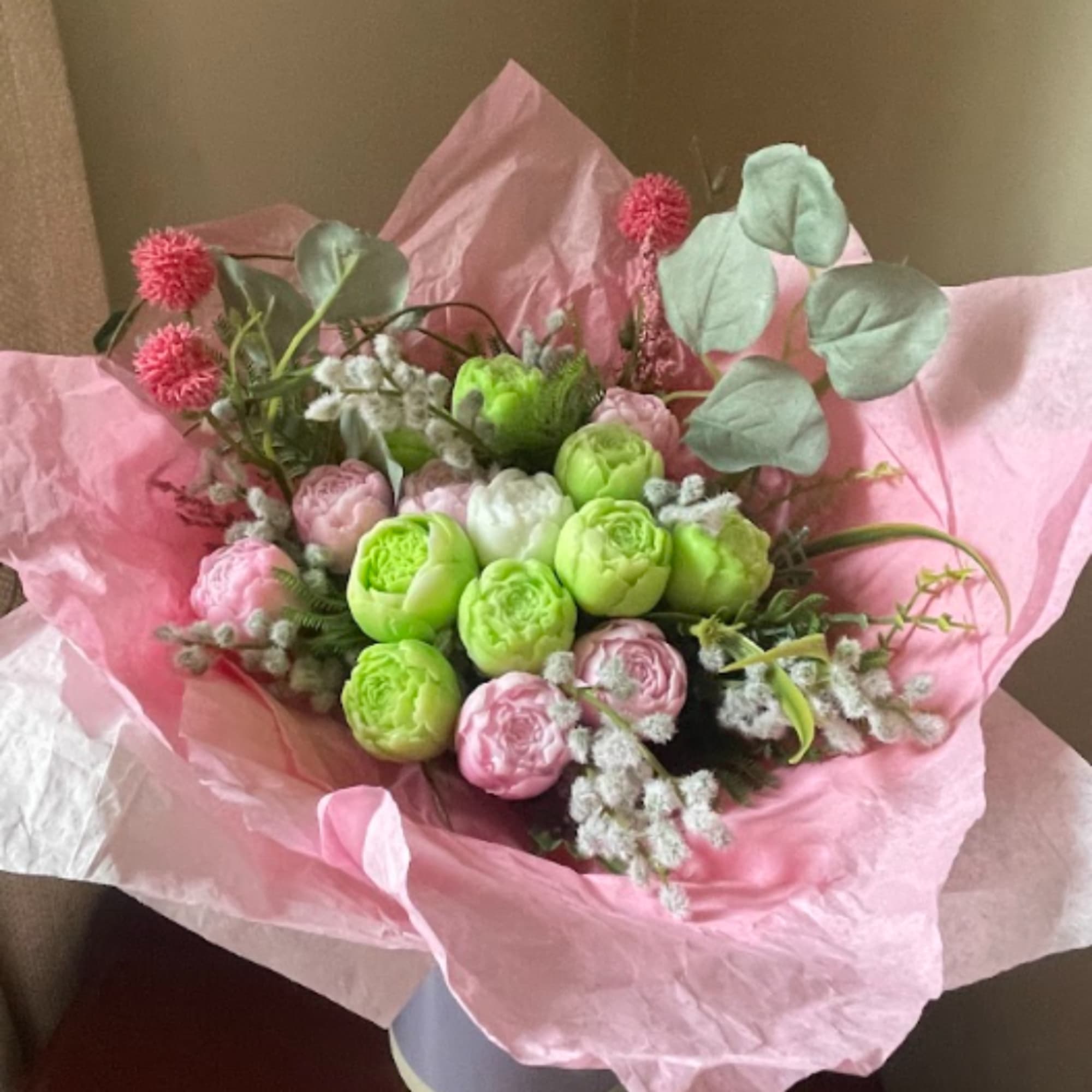 Pink and green bouquet with round blooms wrapped in pink paper