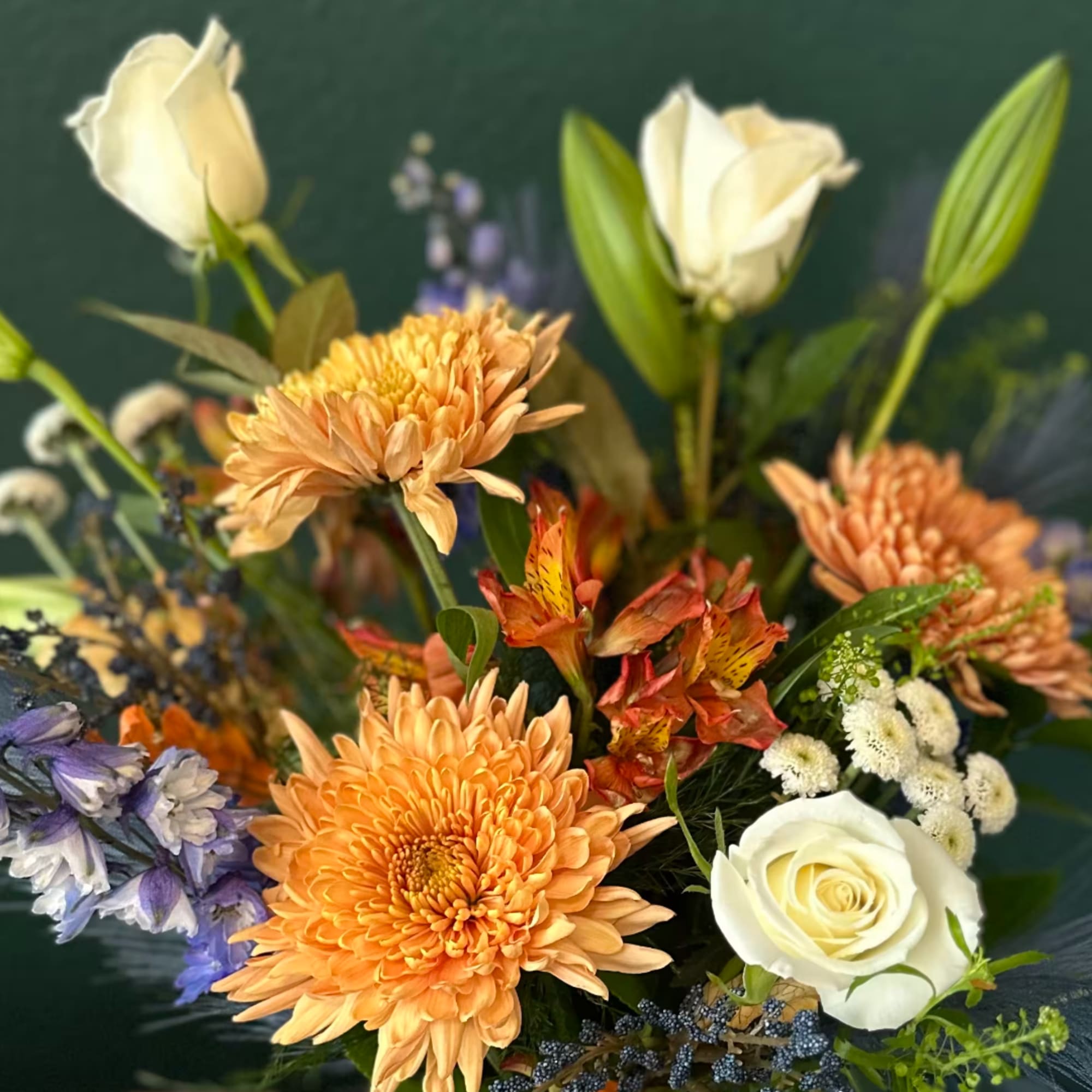 Mixed bouquet with orange chrysanthemums, white roses, and white lilies