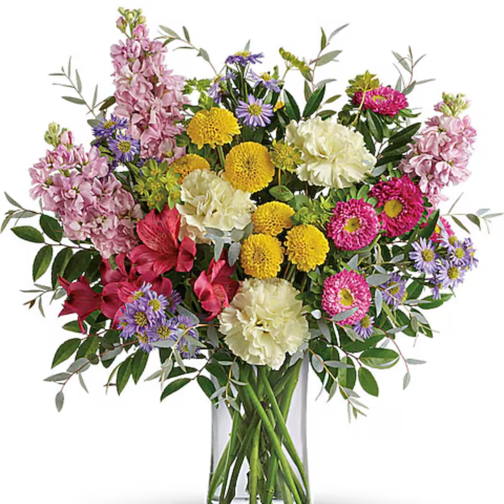 Mixed bouquet of pink, yellow, white, and purple flowers in a clear glass vase