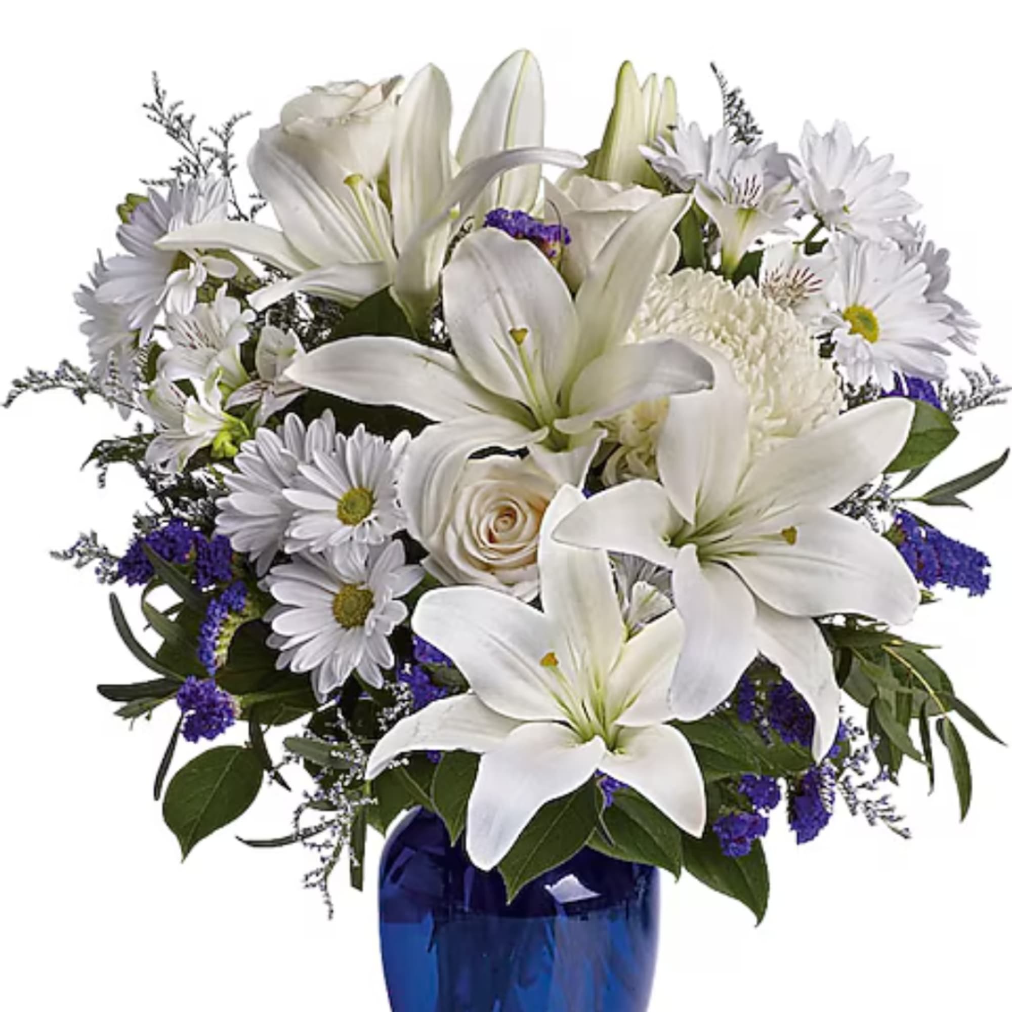 White lilies and daisies arranged in a blue glass vase