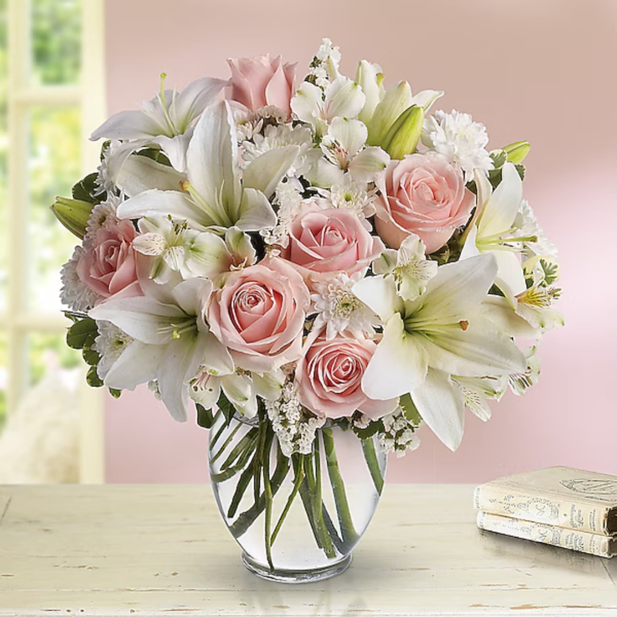 Pink roses and white lilies arranged in a clear glass vase, photo 2 of 2