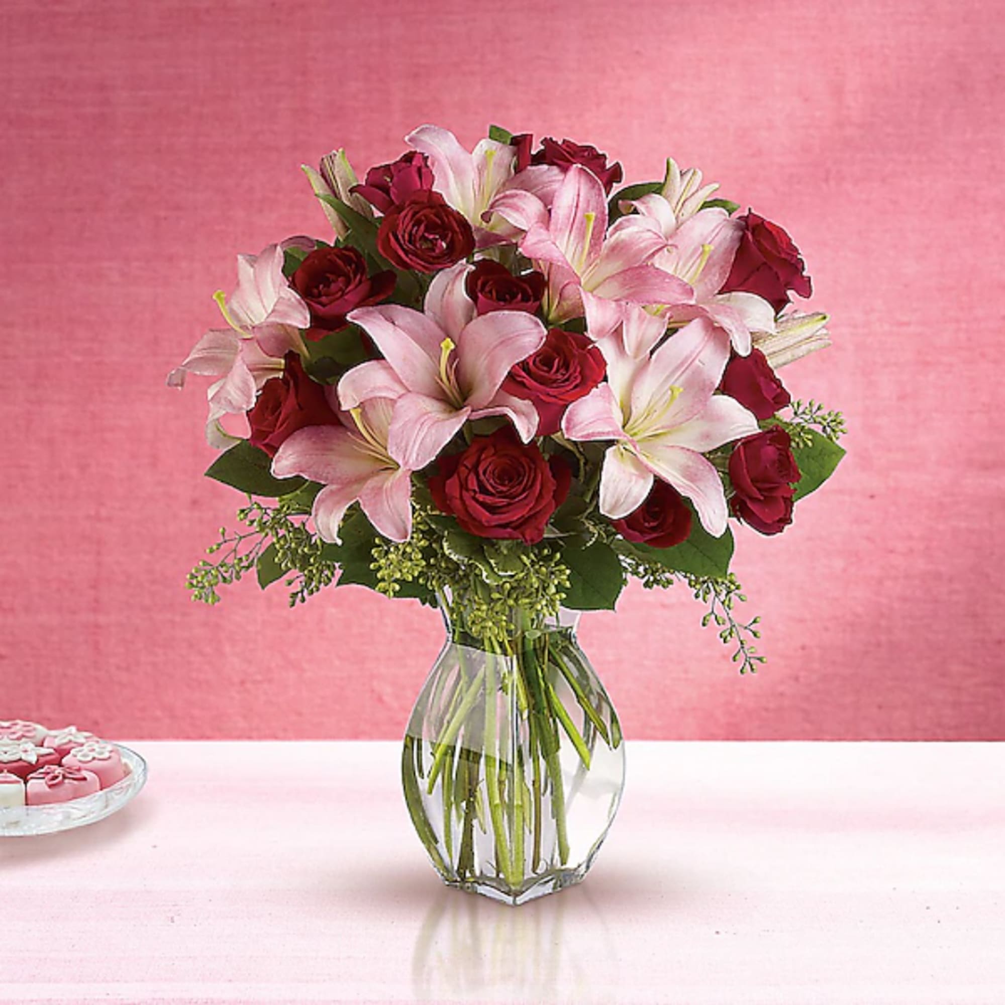 Bouquet of pink lilies and red roses in a clear glass vase, photo 2 of 2