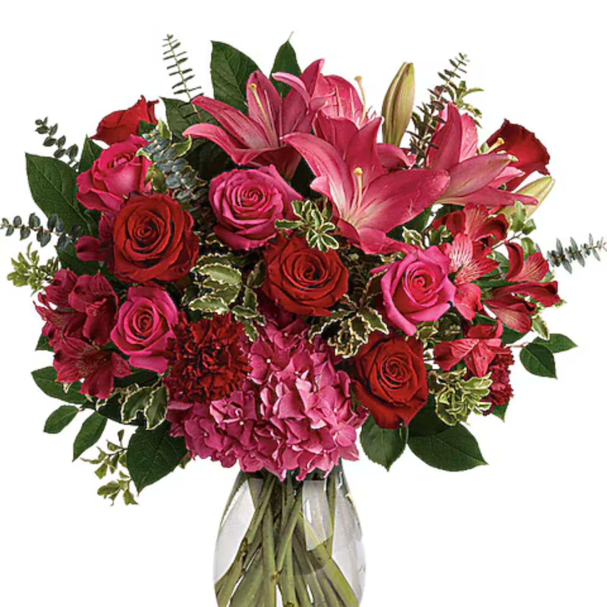 Bouquet of pink lilies, red roses, and hydrangeas in a glass vase