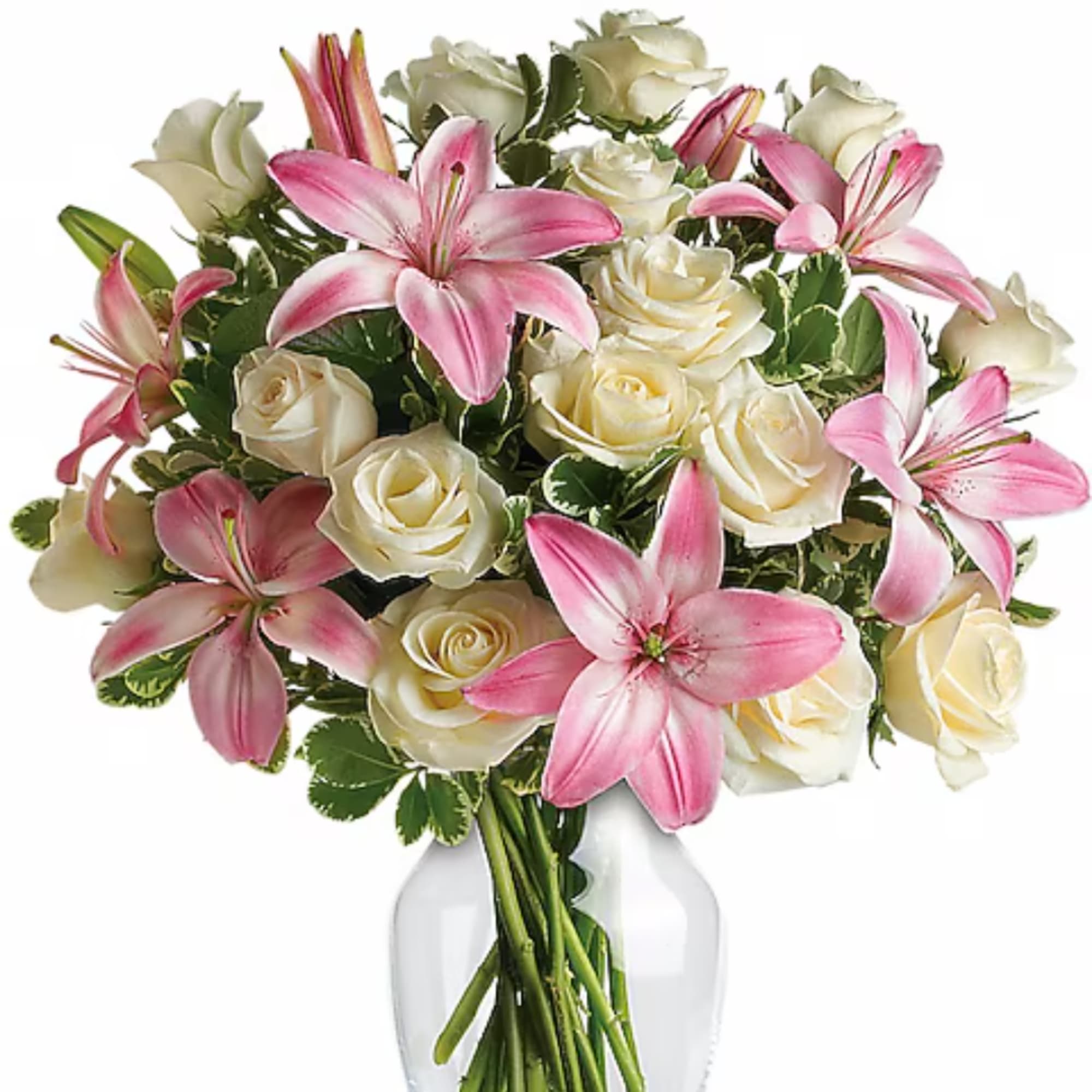 Pink lilies and cream roses arranged in a clear glass vase