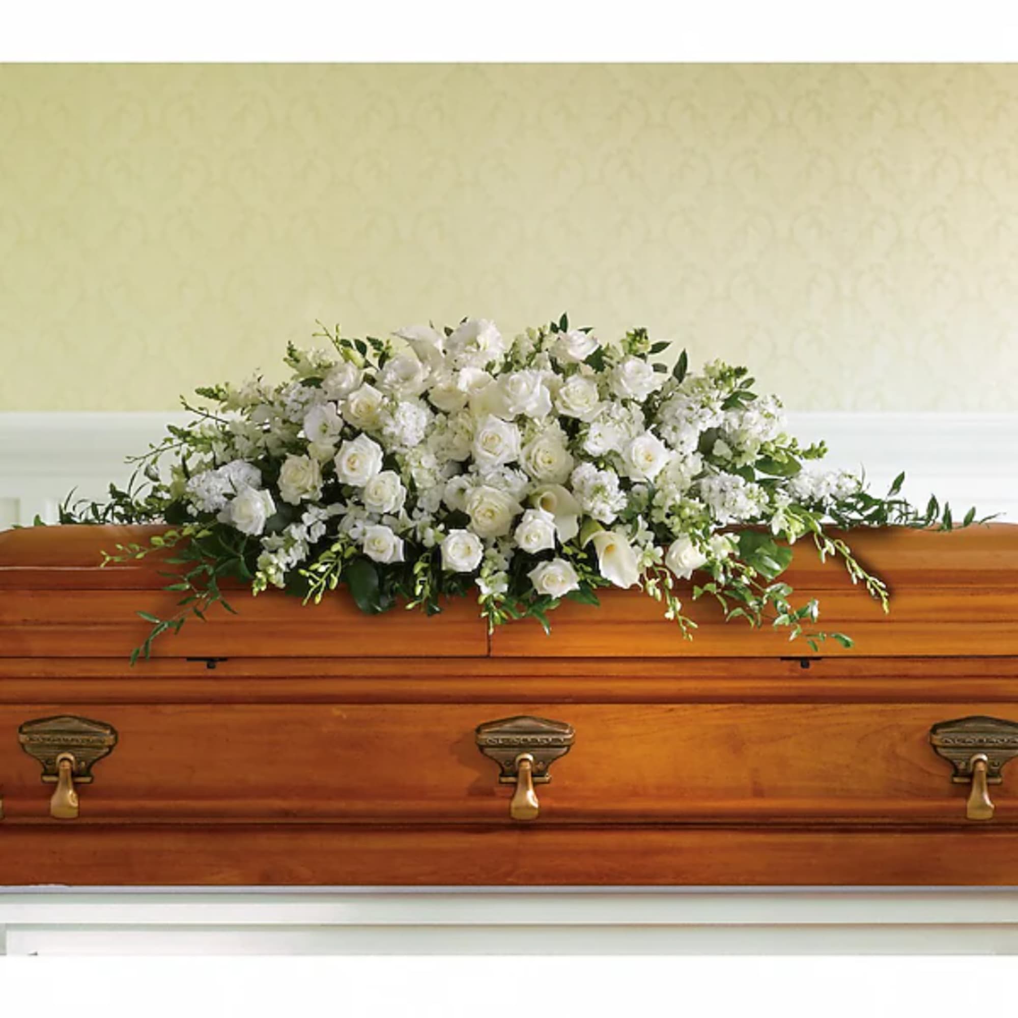 White floral spray arranged on a wooden casket