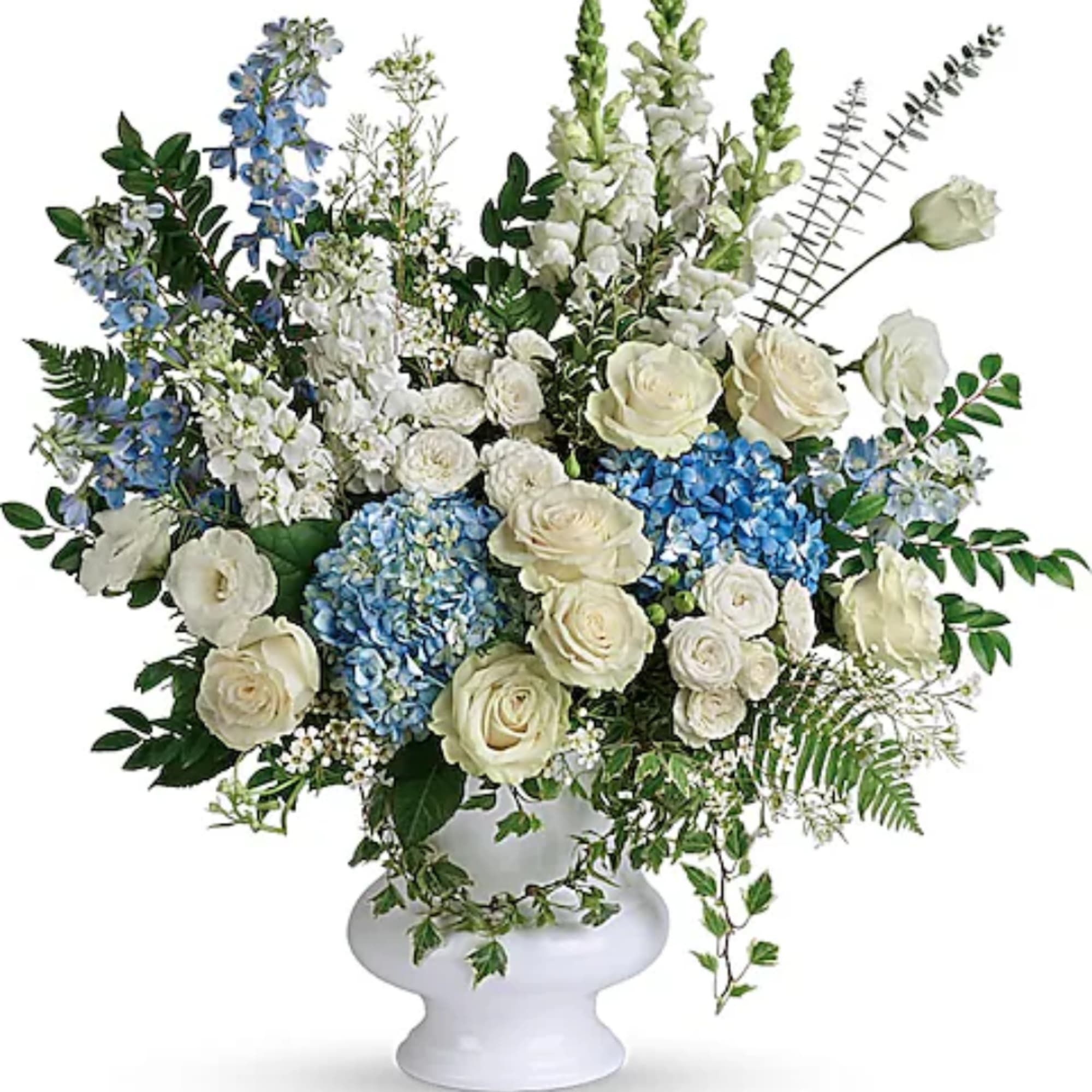 White and blue floral arrangement in a white pedestal vase
