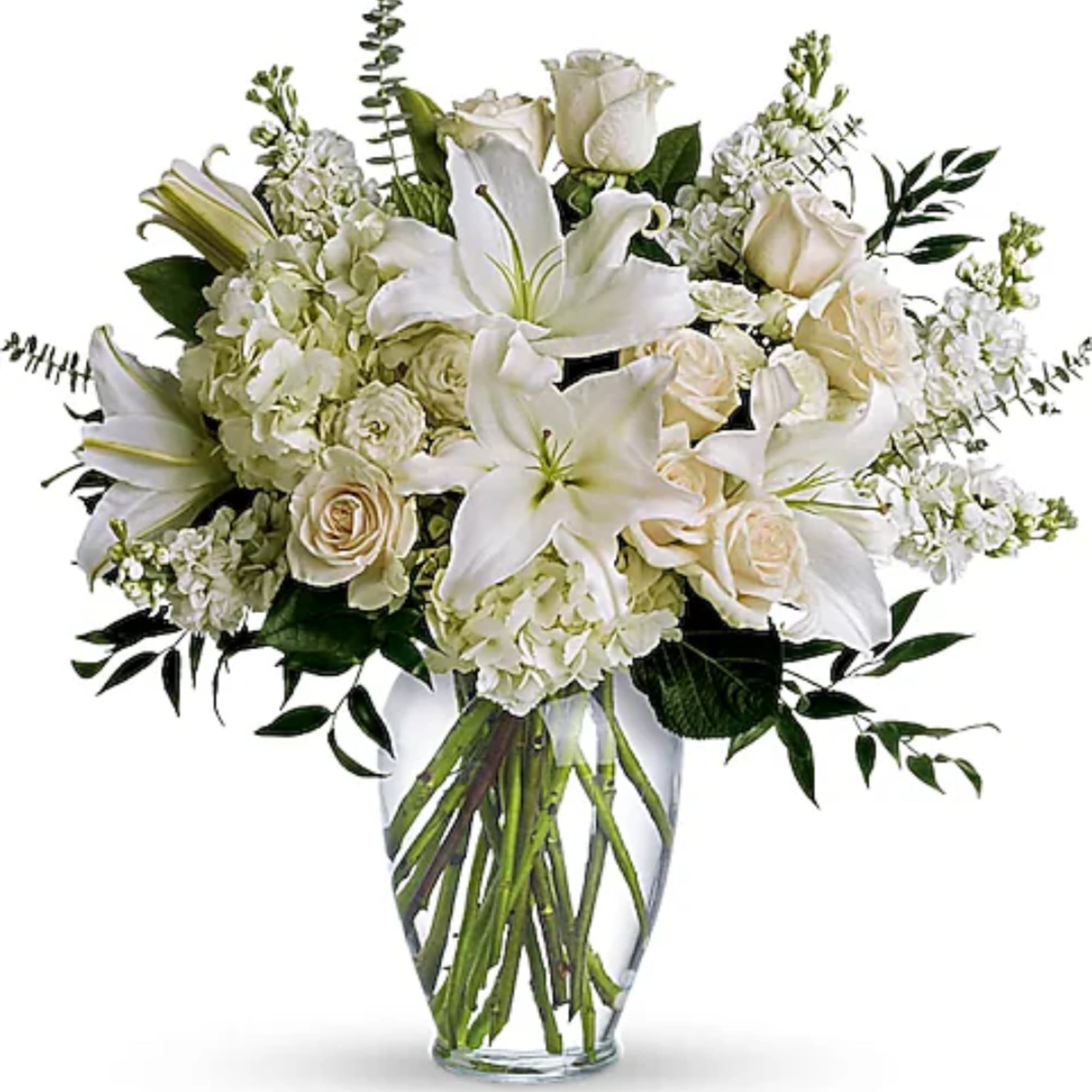 White lilies and roses arranged in a clear glass vase