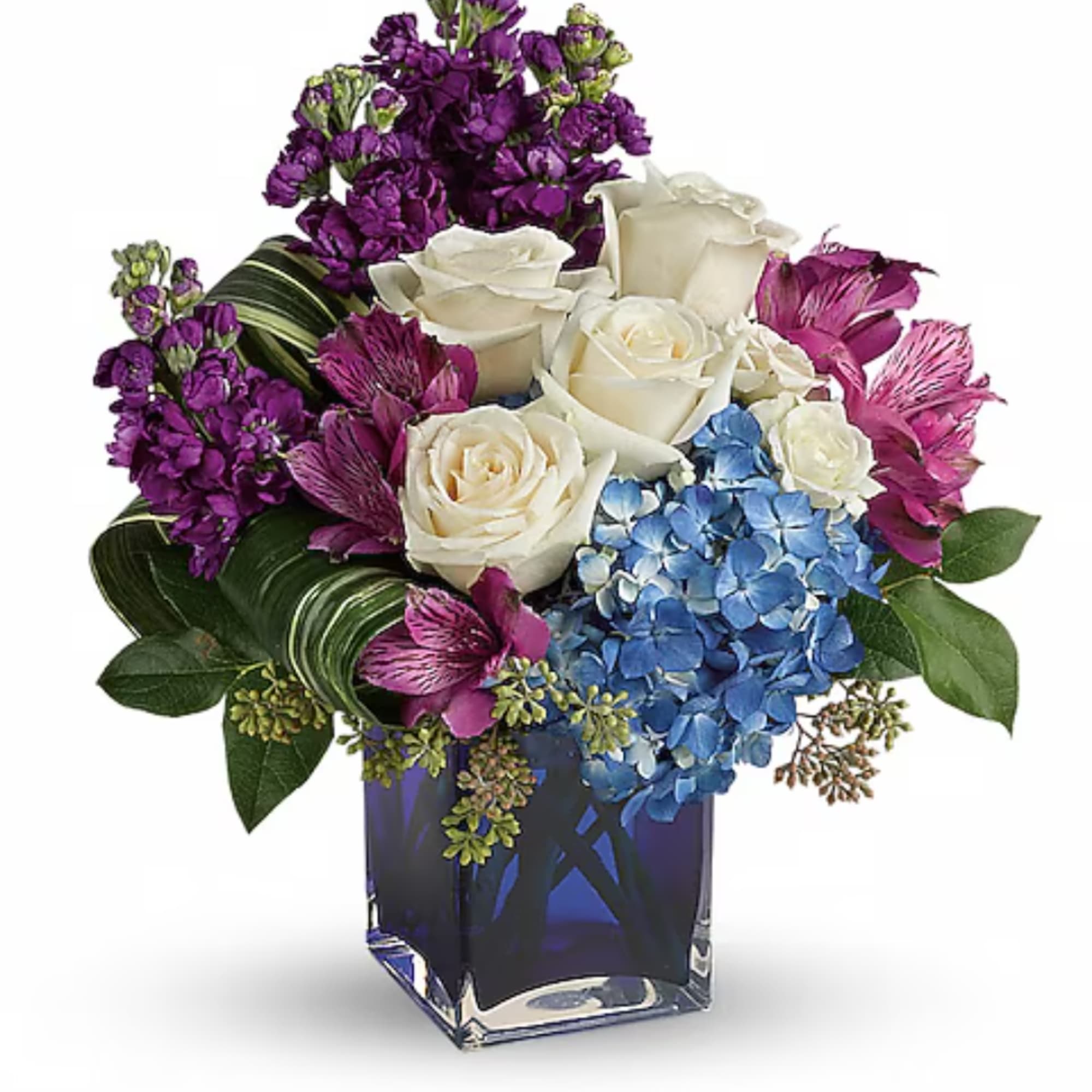 Purple and white floral arrangement in a blue glass vase with blue hydrangea