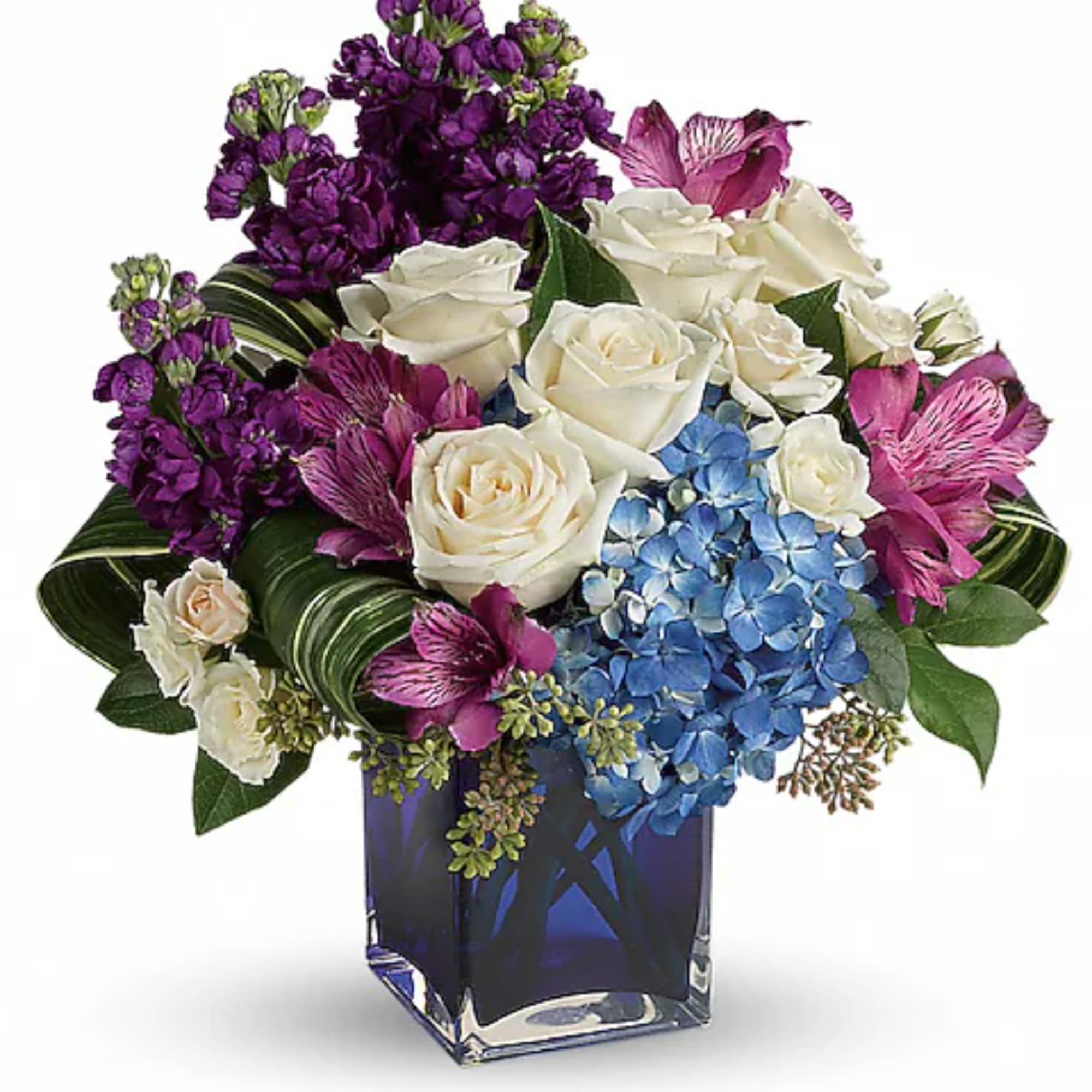 Bouquet of white roses, purple flowers, and blue hydrangeas in a blue glass vase