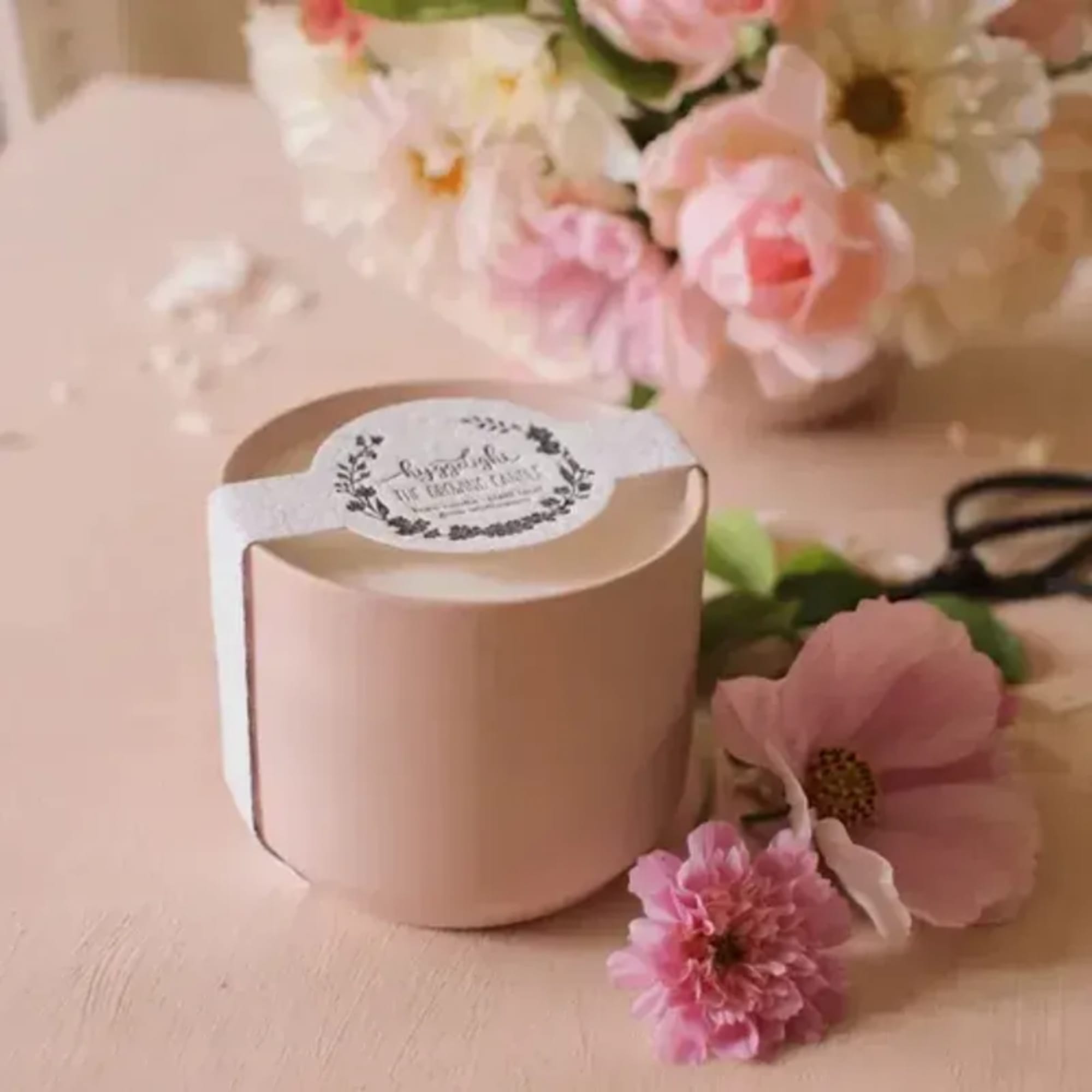 Pink floral gift box with a ribbon and scattered pink blossoms