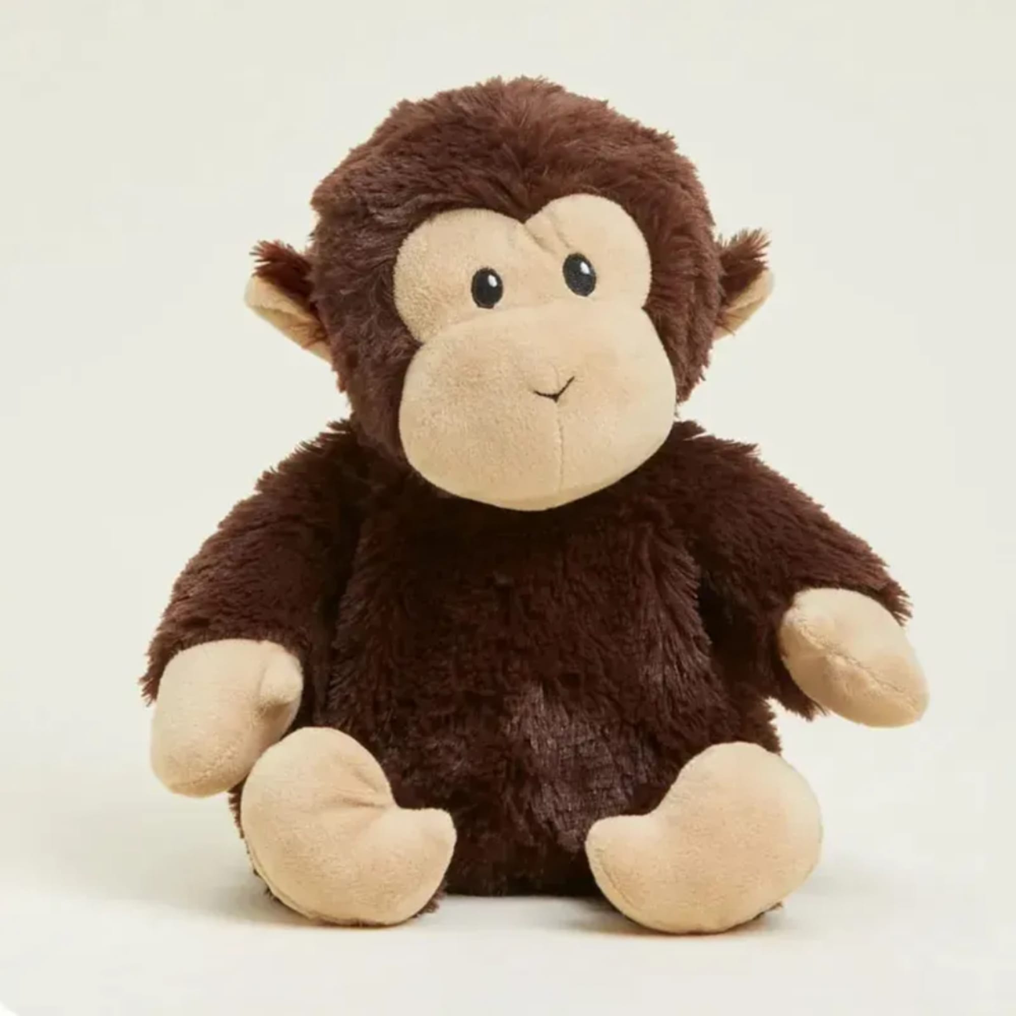 Brown plush monkey stuffed animal sitting on a plain background