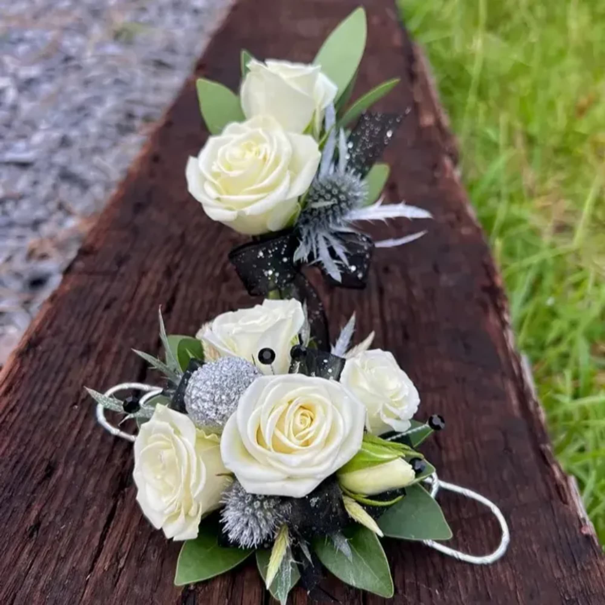 White rose corsage and boutonniere set with black ribbon accents