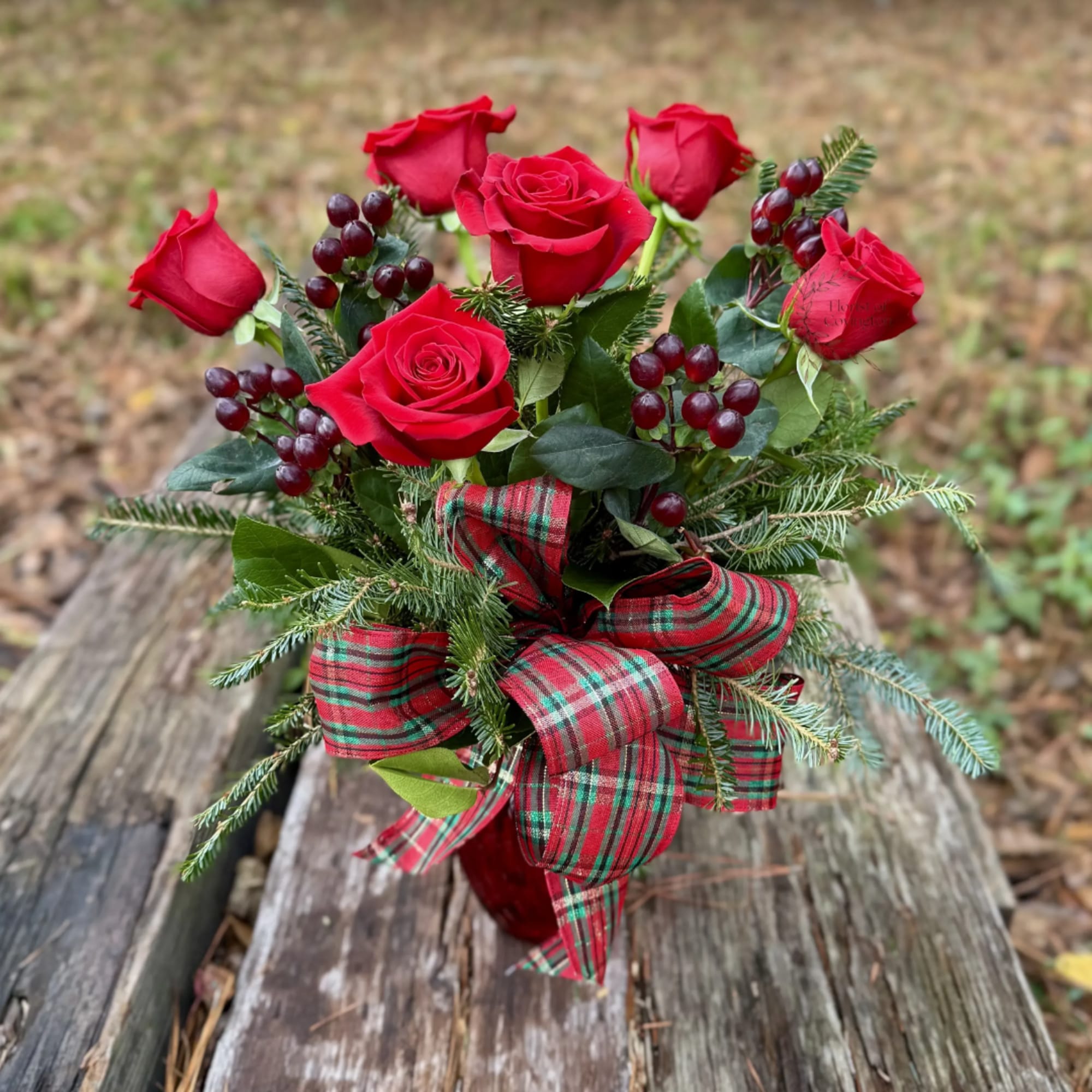 A half dozen roses with berries and winter greens.