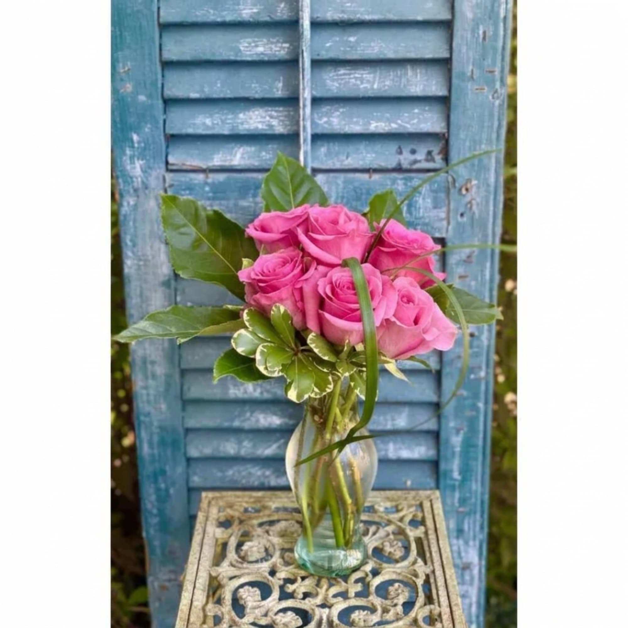 Pink roses in a clear glass vase on a decorative table